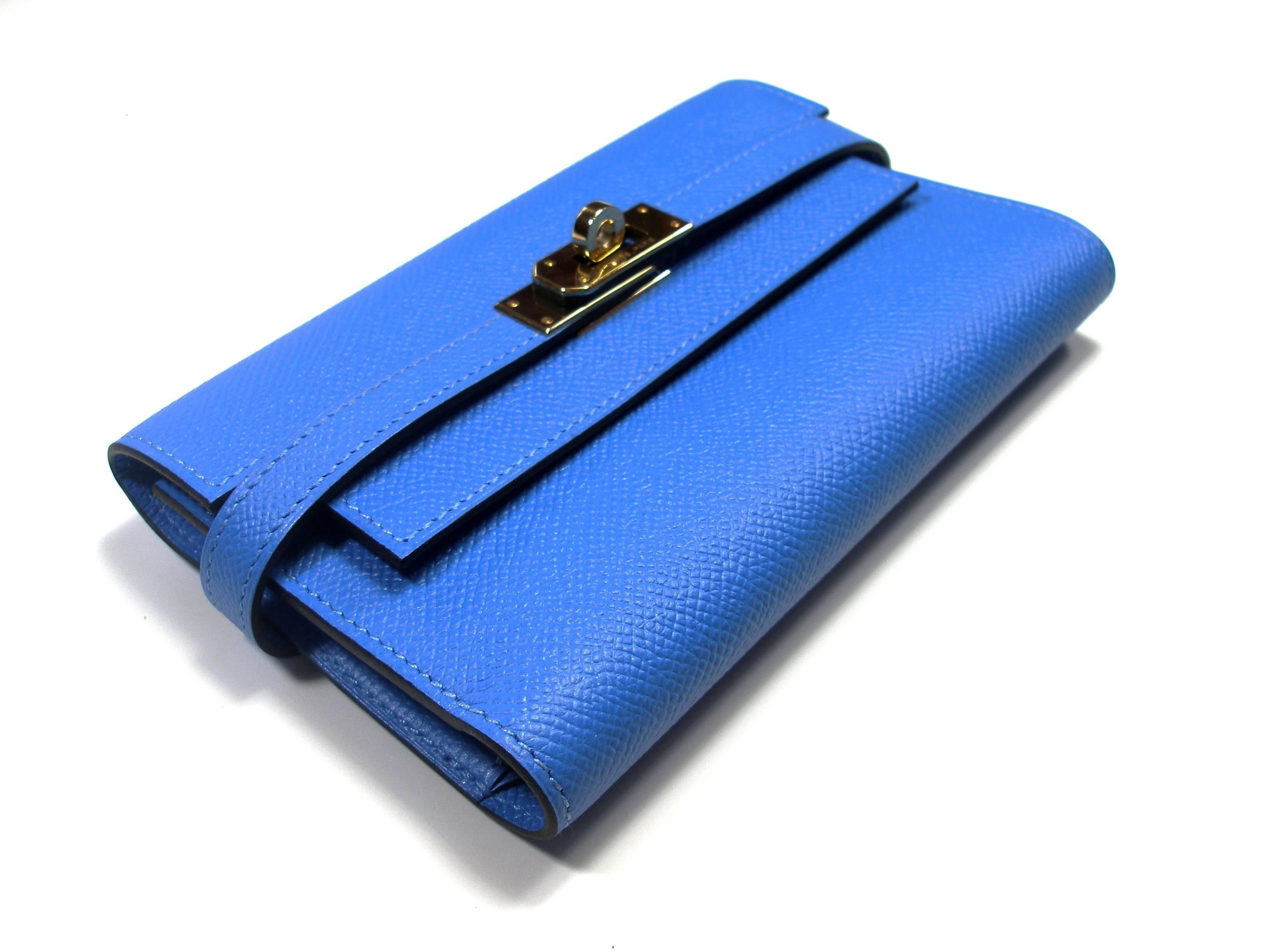 HERMES Chevre Mysore Kelly Compact Wallet Bleu Paradise. This stunning clutch wallet is finely crafted of bright fuchsia chevre goatskin leather. The front flap and polished palladium turn lock open to a matching leather interior with a flap pocket,