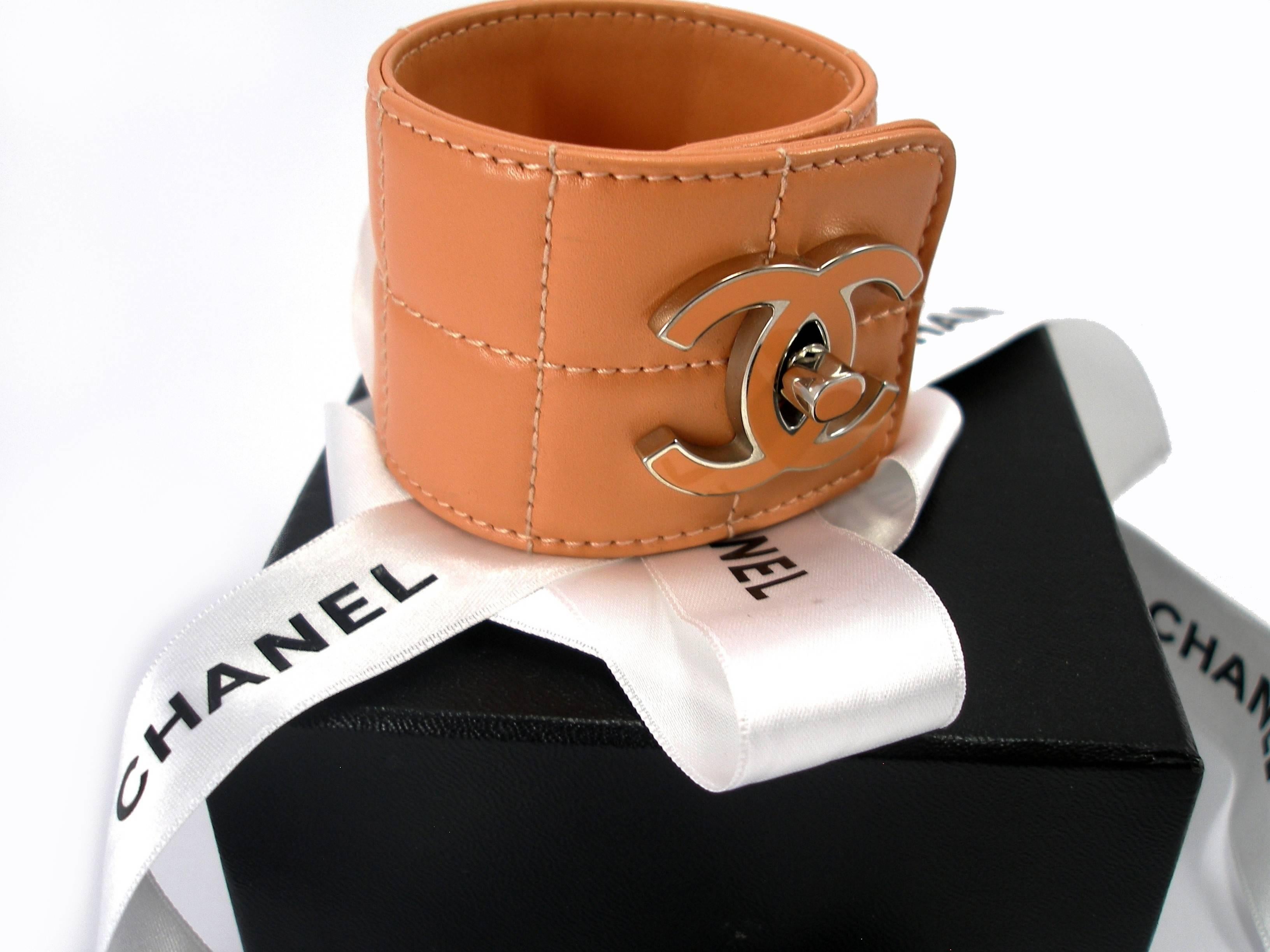 This is a rare vintage quilted leather Chanel cuff.
The width of the cuff is 5 cm 
Diameter : 6 cm 
It has one big Chanel logo with a turn-lock ( enamel )
Color :   rose / saumon 
Its comes with Chanel box and ribbon
