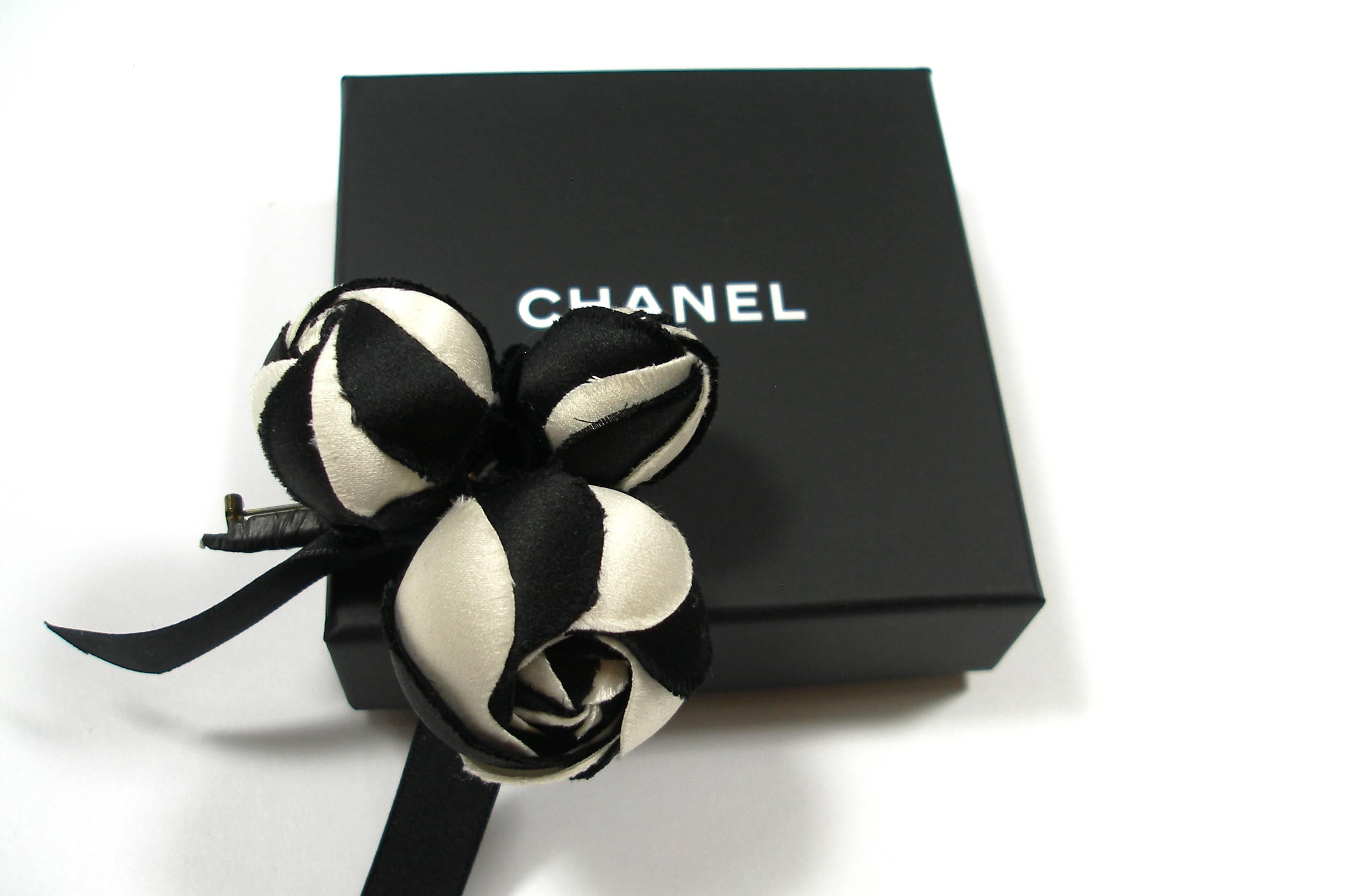 This easy to style classic piece will look good with almost anything. A forever timeless pièce.
Camélia Chanel 
 Black and crème in silk 
Size approx : 6 x 7 cm 
 Excellente condition 
 Made in France
 Year : 1980
 Chanel Made in France on the back