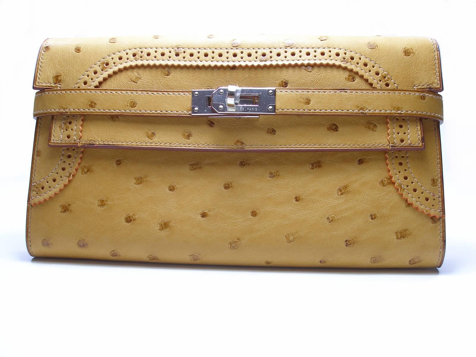 FANTASTIC ...GREAT as an Evening Clutch !
Hermès Kelly Gillies 
Autruche Leather 
Color : Tabac / Camel 
Palladium hardware , signed Hermès Paris
Note : plastic protection is still on hdw 
Measures 4.5