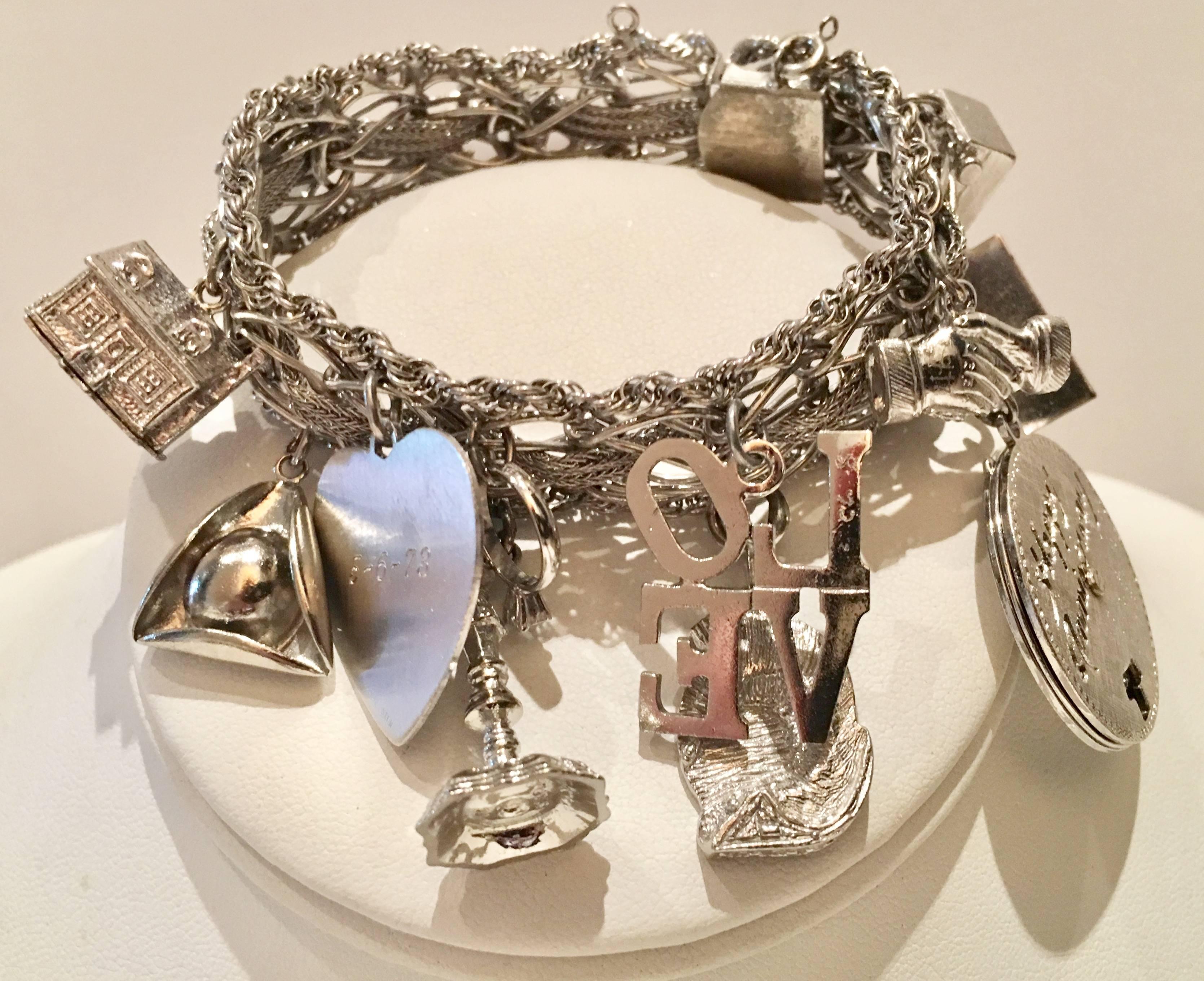 Incredible example of the iconic and popular 1960s collectors charm bracelet. This beauty is one of the most substantial and total sterling silver weighs is 92 grams. Featuring 13 individual charms some of the charms are dated, starting with the mid