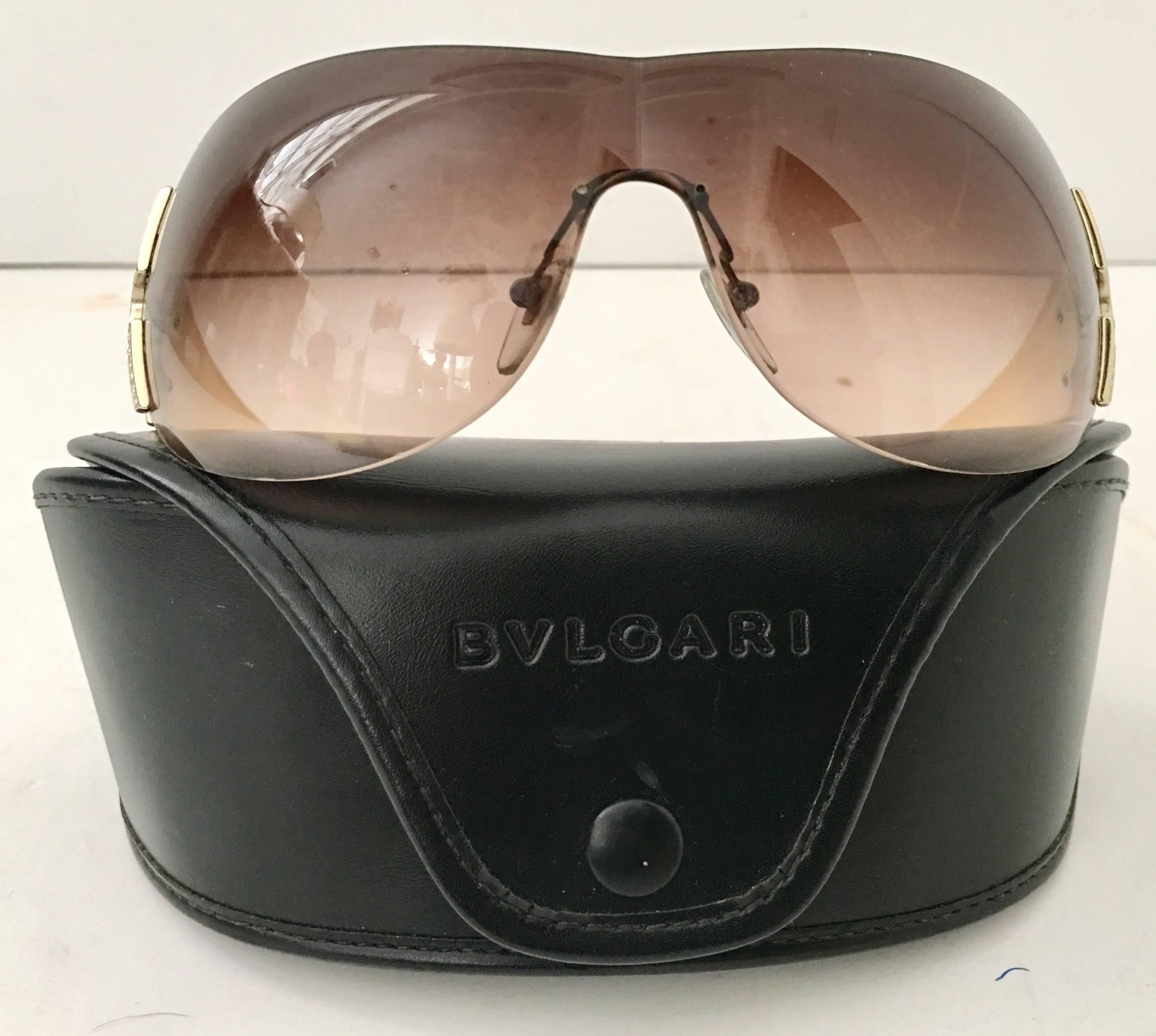Stunning pale pink cased Bvlgari logo sunglasses with brown gradient lenses.
Features Swarovski pave set crystal rhinestone detail set in gold plate. Includes original black soft protective storage case, with embossed Bvlgari logo. Glasses are