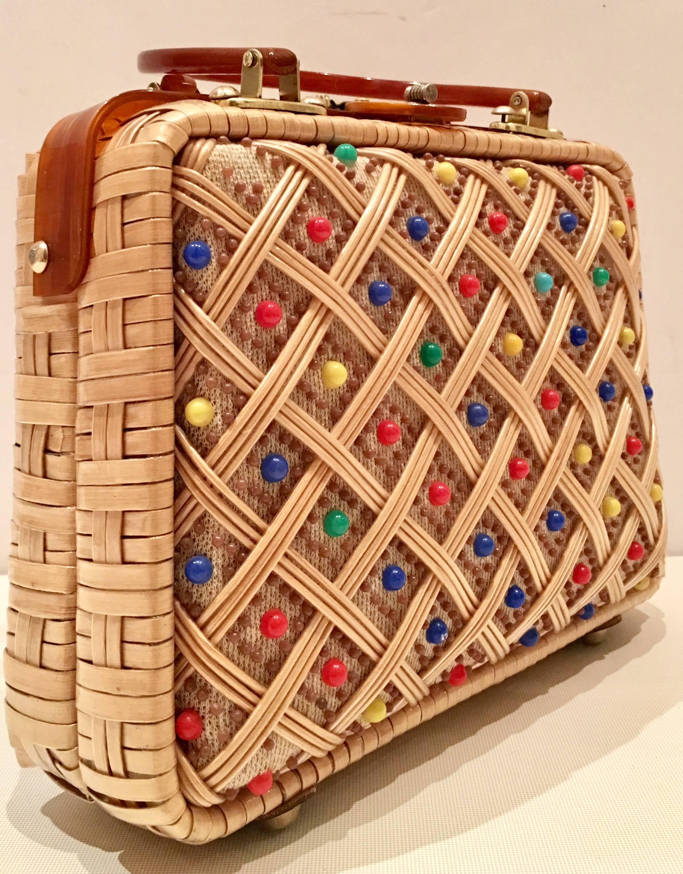 1960'S Wicker and Lucite tortoise dyed lattice handbag. This made in Hong Kong hand bag features, raised resin beads in primary colors and brass hardware detail.
Fully lined in peach colored vinyl and features two interior pockets, one with a zipper
