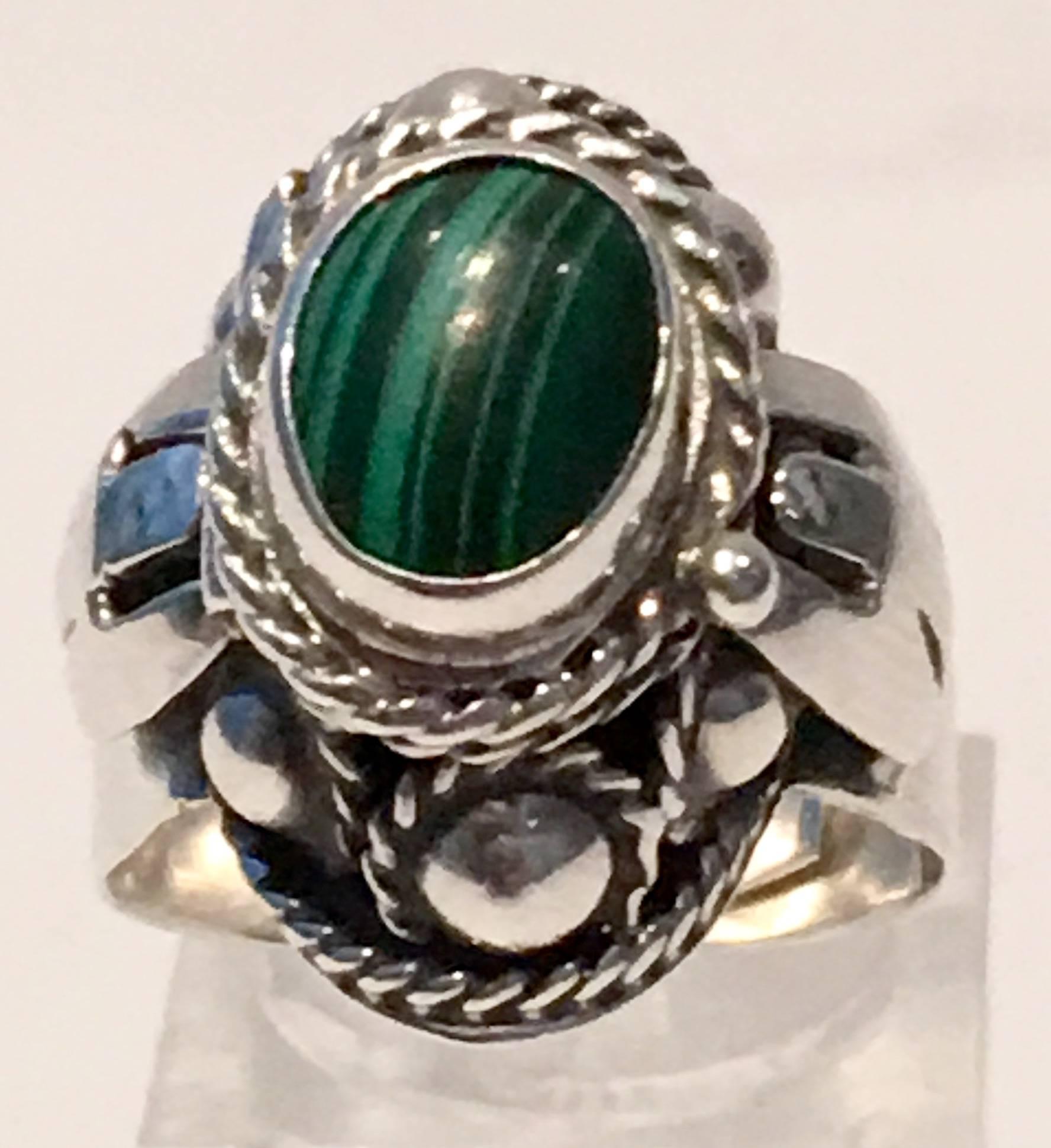 1960'S Sterling silver and malachite stone poison ring. Top of ring is on a hinge that opens like a locket. Malachite stone is approximately .25"D. Artist signed "925 T J 68 Mexico." Adjustable to fit almost any size, currently set at