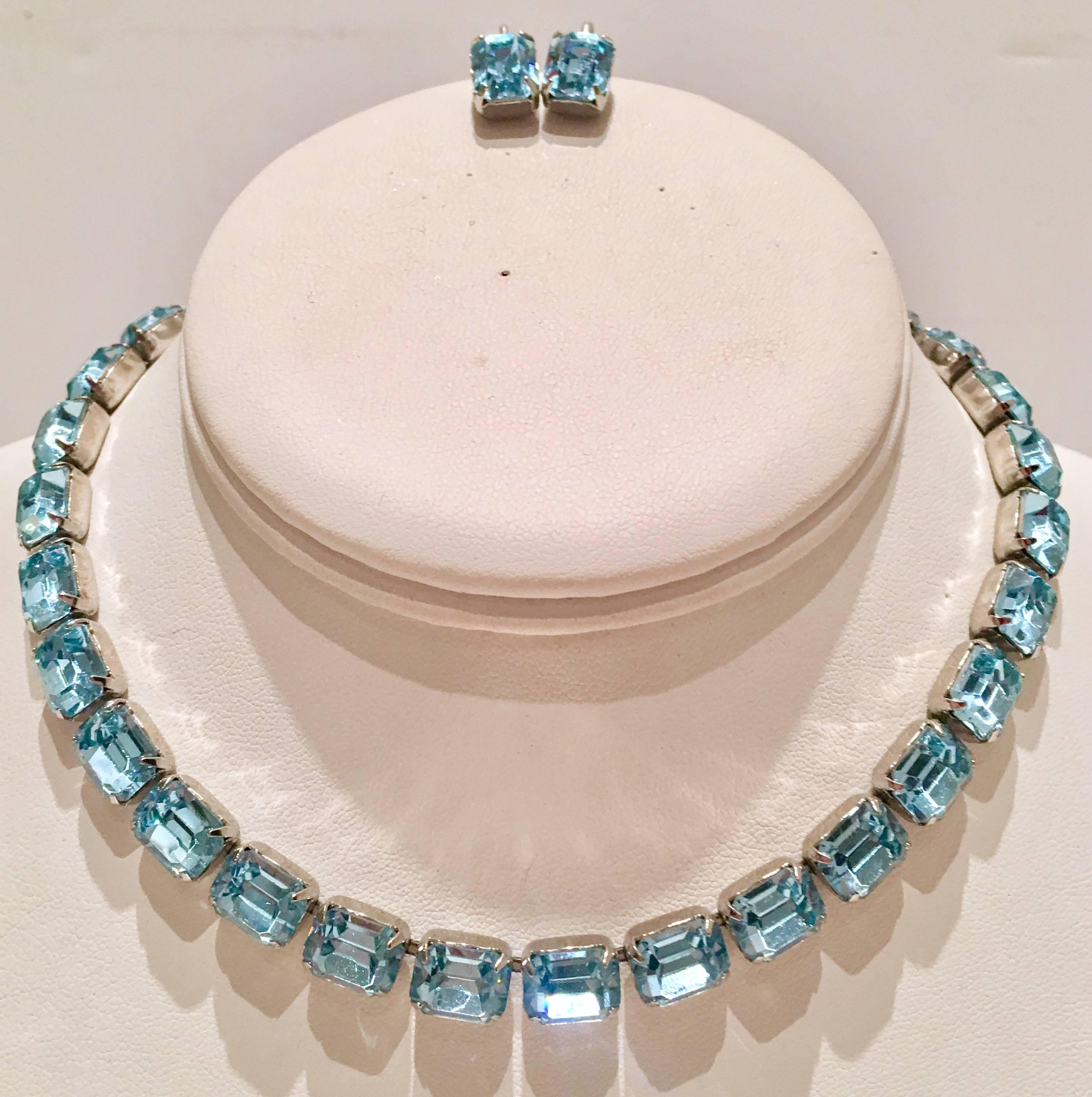 Vintage signed Weiss brilliant sapphire blue Austrian cut crystal three piece set. Set includes a choker style necklace and clip style earrings.
Set in silver tone metal, prong set brilliant emerald cut shape stones. The necklace features a hook