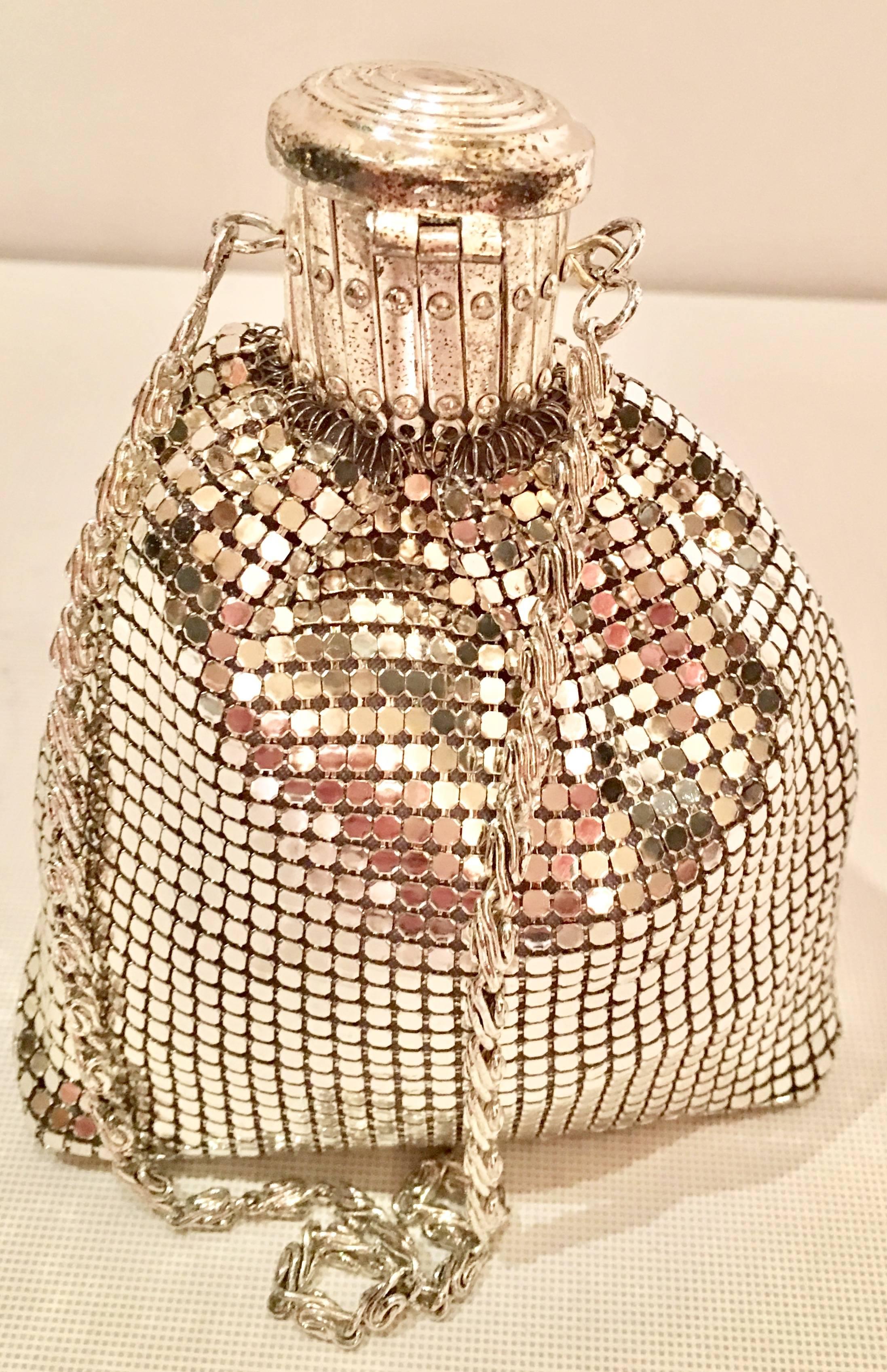 Whiting & Davis Silver Metal Mesh gate top wristlet beggars purse. Features a metal mesh body with a silver plate gate top snap closure with spiral motif. Fully lined in silver satin lining and the bottom is reinforced with a hard interior panel.