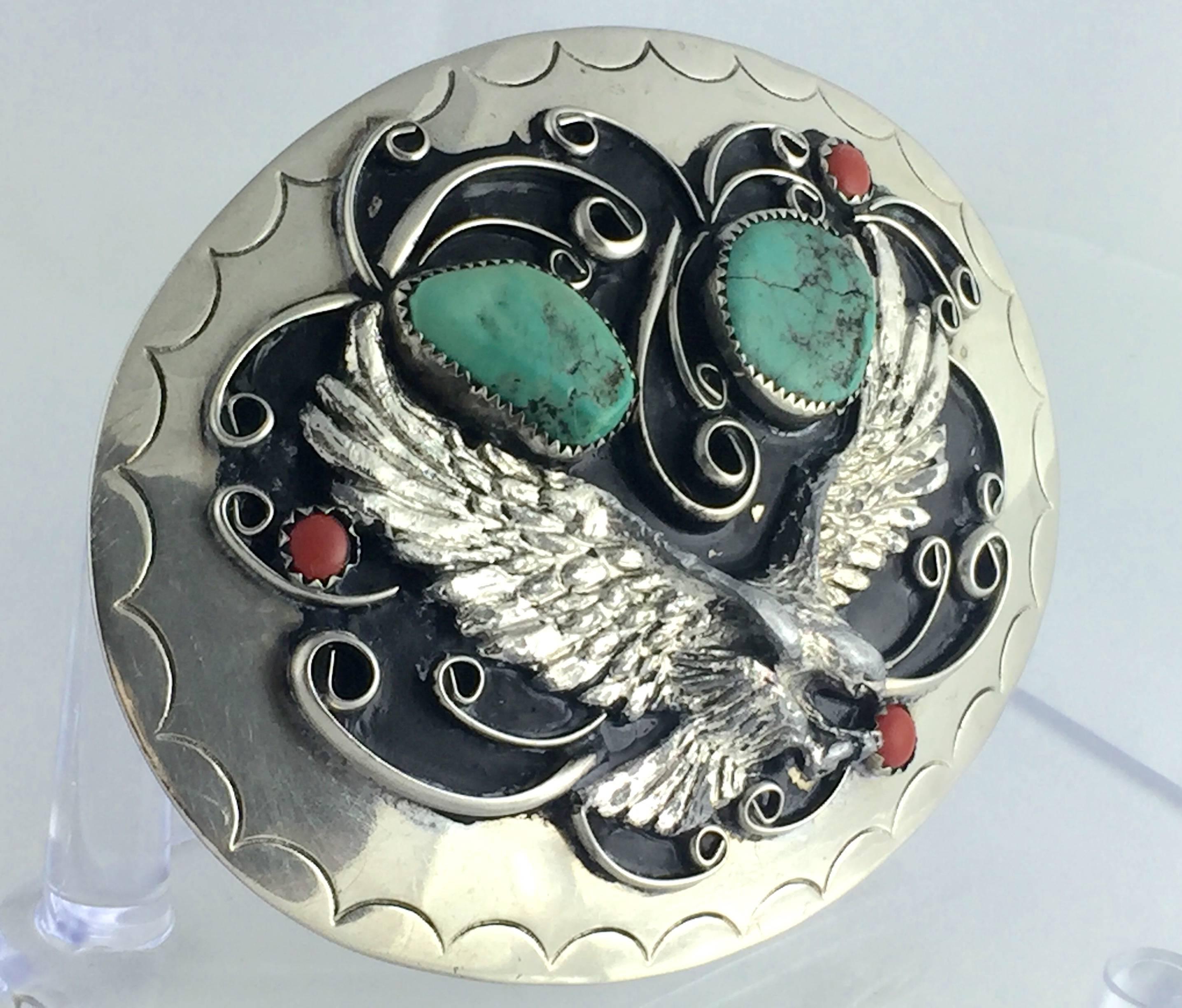  1970'S Squaw Wrap signed "German" silver, turquoise and coral "Thunderbird" flying eagle belt buckle. Features a "Thunderbird" in flight with 3D detail, two large chunky authentic turquoise stone and three genuine red