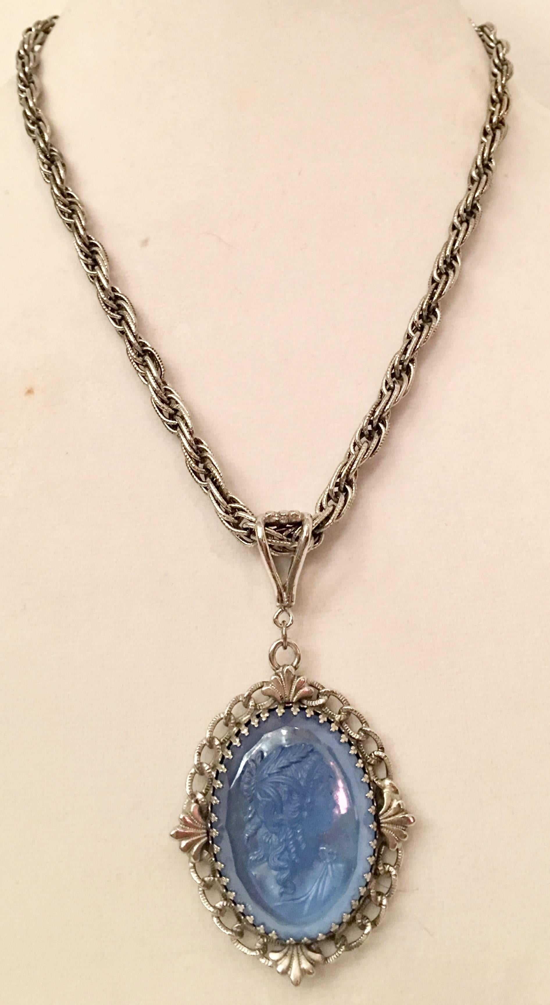 1960'S Silver and carved blue glass high relief cameo pendant necklace by, Whiting & Davis. This two piece necklace features a female profile, right facing blue carved glasses cameo pendant. The carved glass cameo pendant is set in silver rhodium