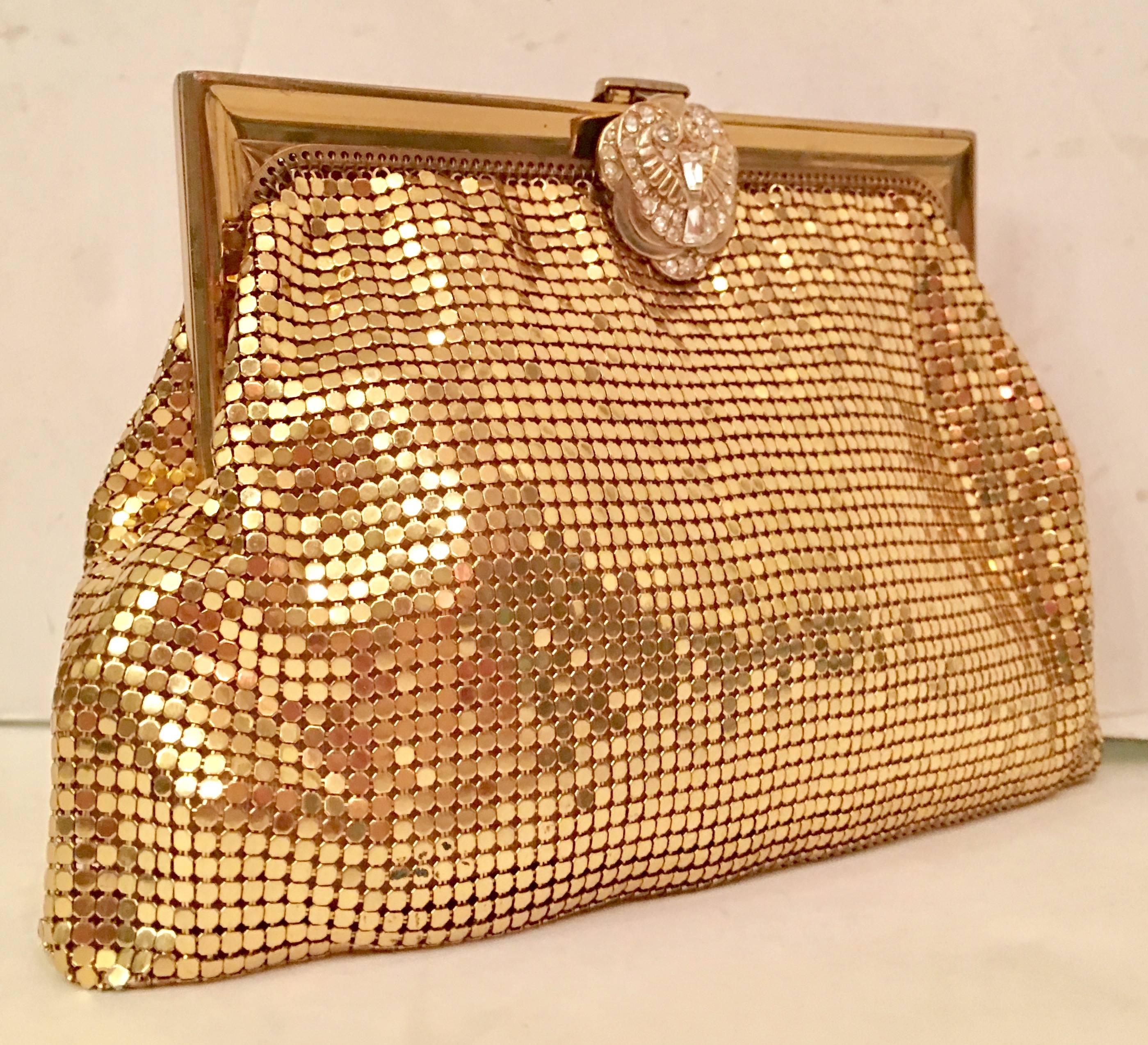 Vintage Art Deco style Whiting & Davis gold metal mesh clutch evening bag. Features a gold/brass plated metal mesh soft body and hard gold/brass plated metal frame and snap closure. The Art Deco style soft snap closure is adorned with clear