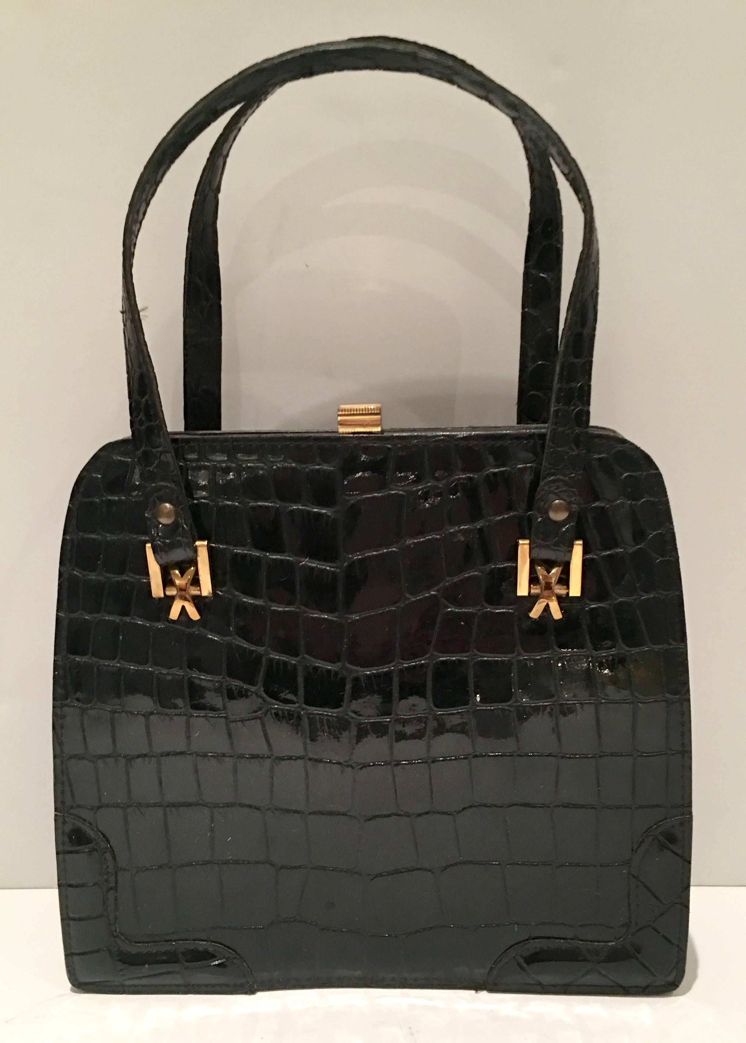 1950'S France Black Patent leather crocodile embossed handbag with gold brass hardware and double shoulder straps.. This timeless & Coveted hand bag features a snap closure is fully lined with an storage interior pocket. The original