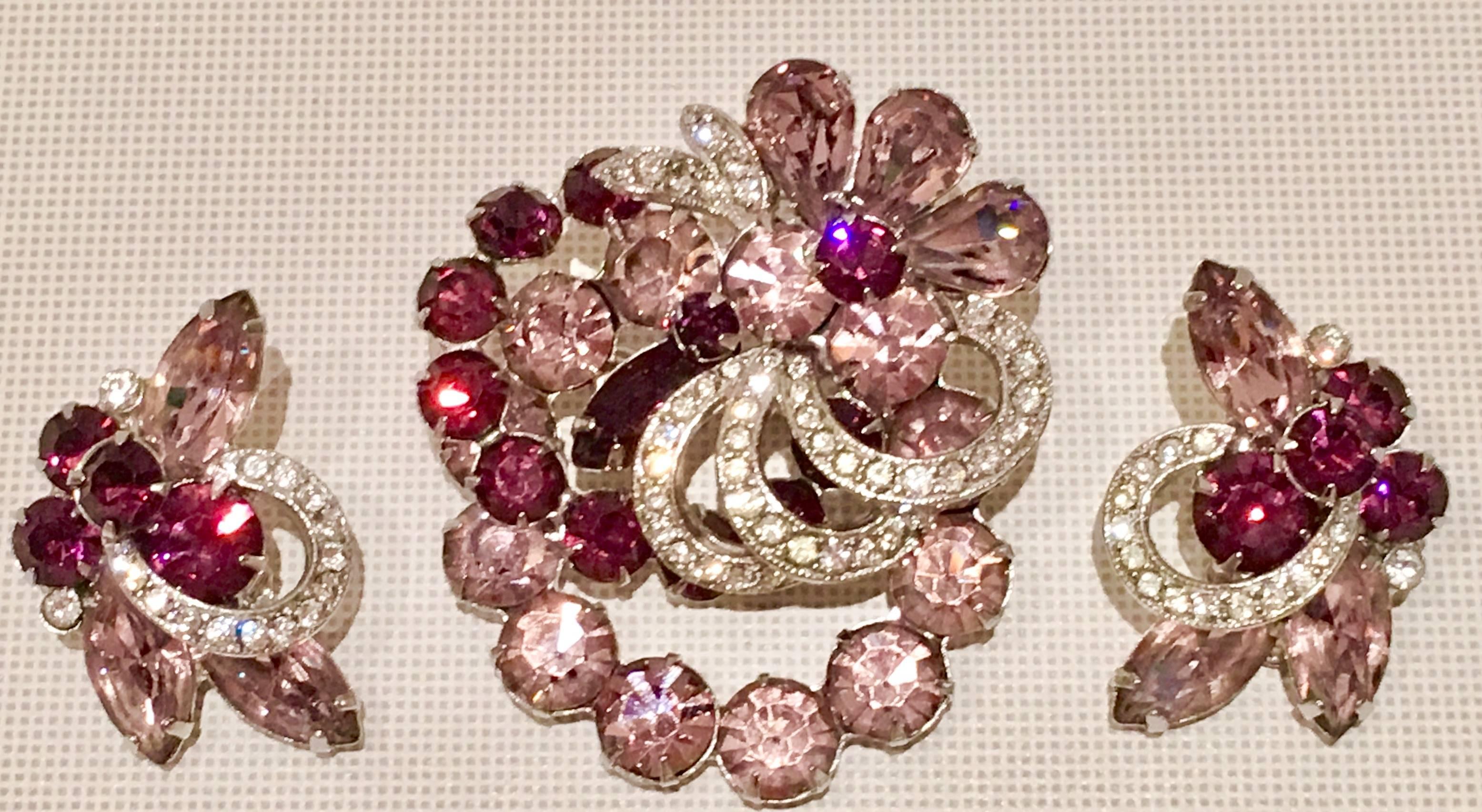 Stunning & Rare signed Eisenberg"Ice" demi parure brooch and earring set. Swarovski crystal rhinestones in clear and amethyst set in silver tone rhodium plated metal.
Earrings are clip style and measure 1.13" in diameter.