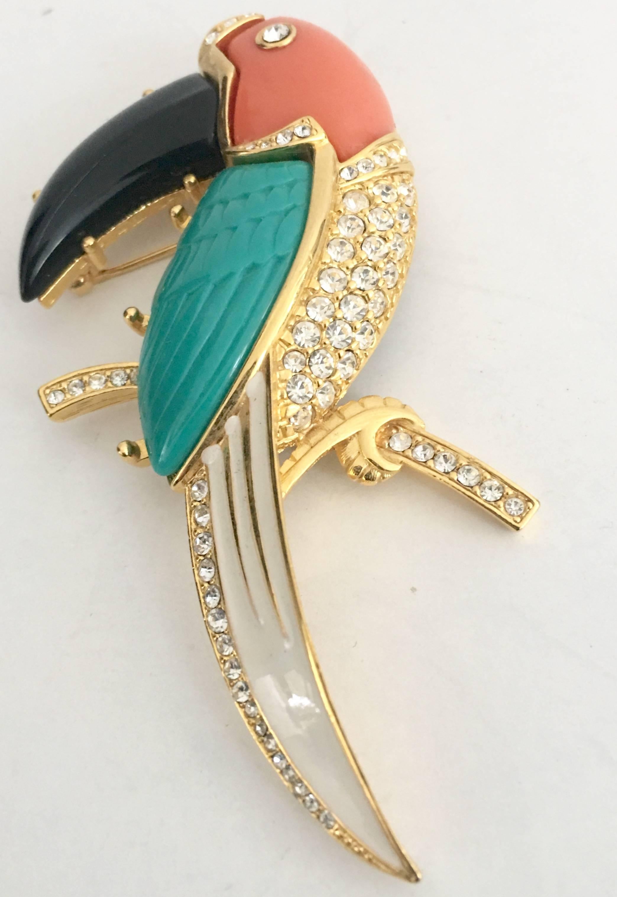 Kenneth J Lane Signed gold-plate with crystal clear rhinestones Toucan Bird Brooch. Features, enamel and faux resin coral, turquoise and black onyx with pave set Swarovski crystal clear rhinestones . brooch. Signed "KJL" on the underside.