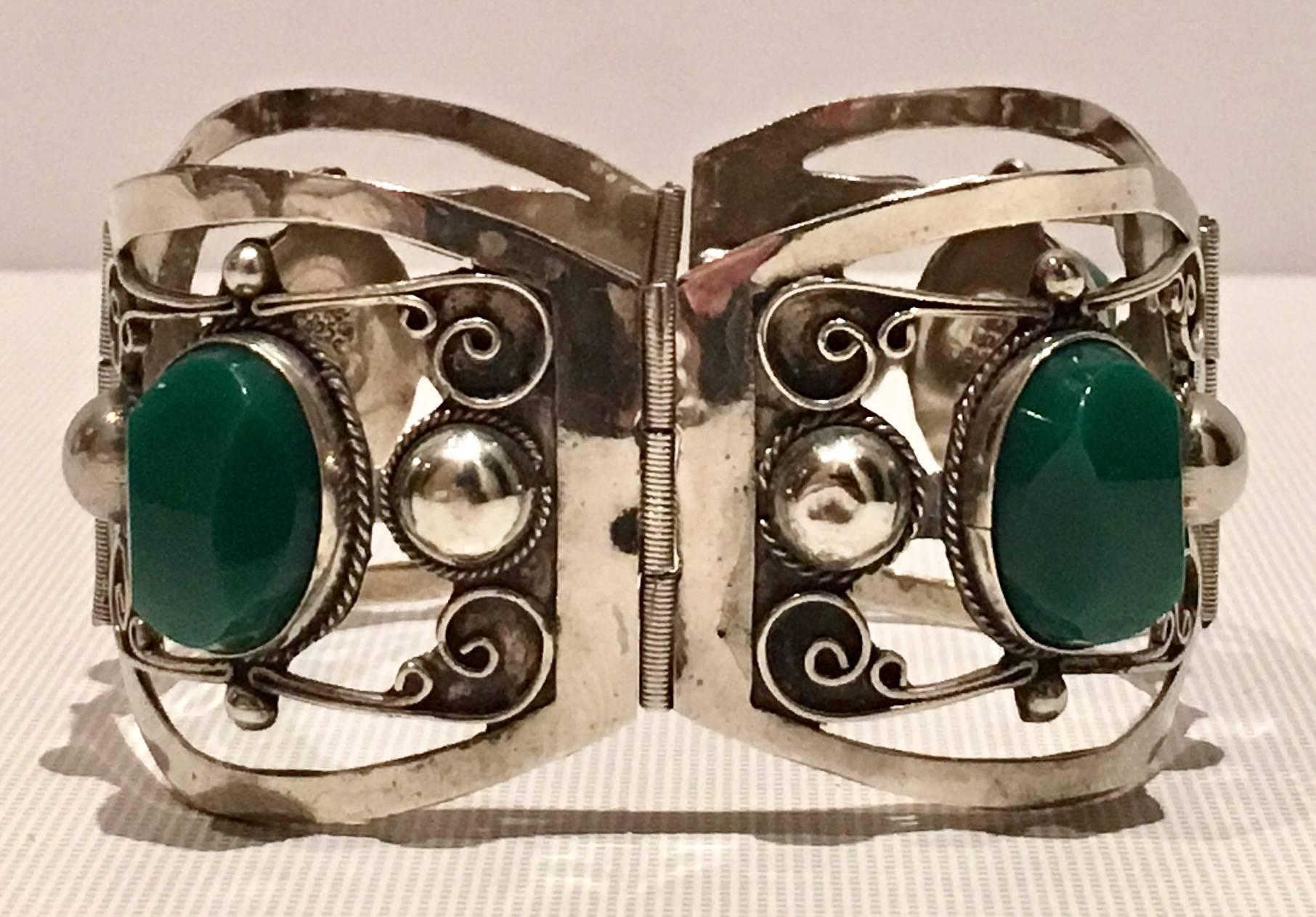Mid-20th Century Sterling Silver 925 dyed emerald green chalcedony stone panel link bracelet. Features four panels with polished and faceted cabochon set stones and intricate silver filigree open work. Signed Sterling 925-Mexcio with Taxco artist