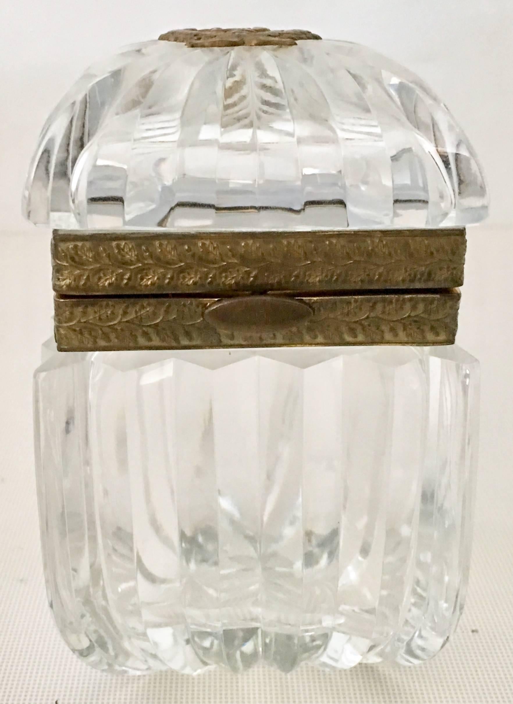 Early 20th Century French Cut Crystal & Bronze Ormolu Lyric Crest Hinge Casket Box. Features a modern cut
crystal body, bronze ormolu locking and hinge detail. The top of the box is 