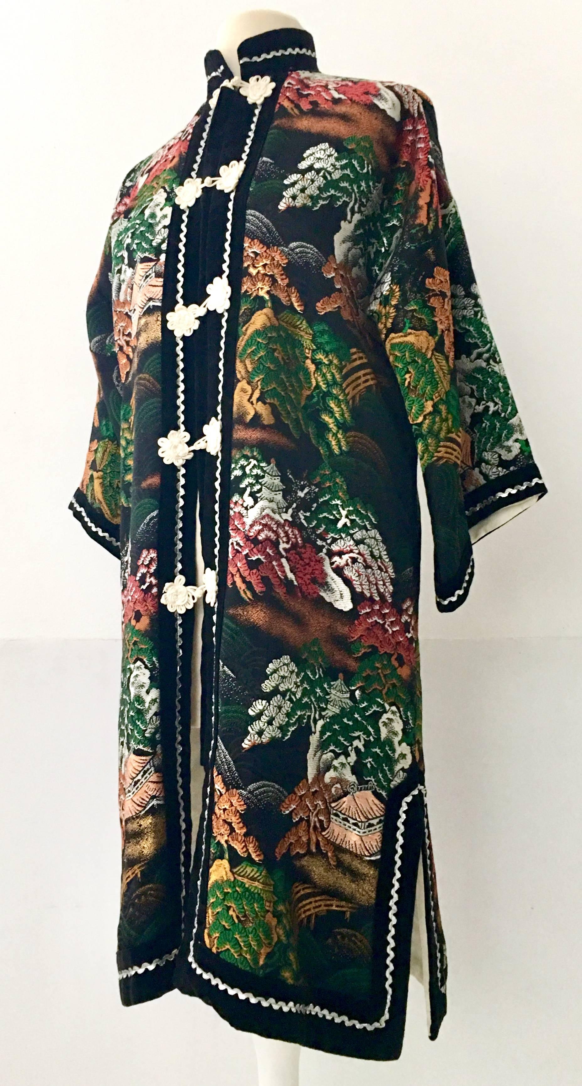 1970'S Silk Embroidered Kimono Style Hong Kong Jacket. This silk satin blend Hong Kong piece features a jet black ground with metallic thread embroidery in orange, emerald, peach, gold and white depicting a Bonsai , rolling hill and tree landscape