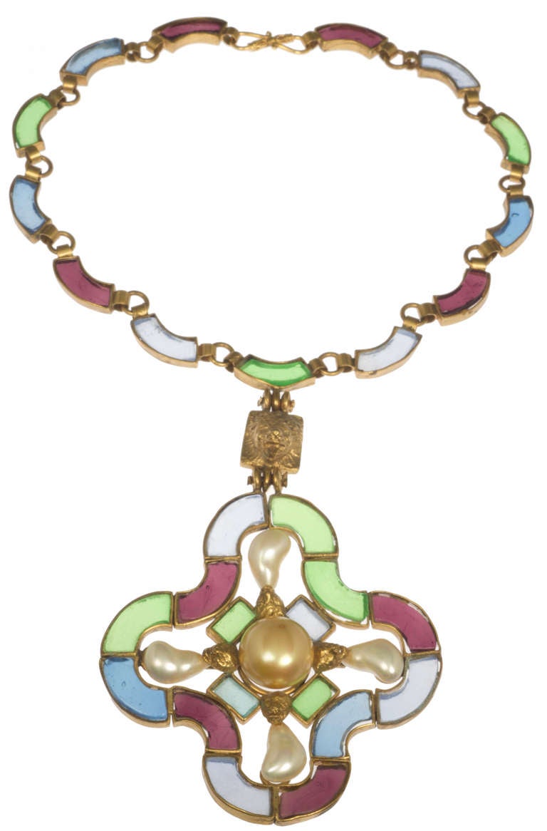 This is a beautiful necklace, boasting unusually shaped pearls. Without a doubt, this is one of Robert Goossens' masterpieces for Chanel. Great color in the glass, different blues, greens and violet. A golden lion element joins the medallion to the