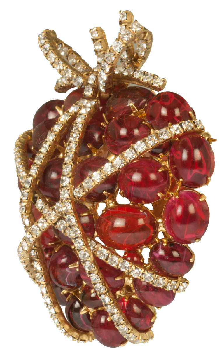This is an early and stunning  piece by Moini.  It is an homage to a ruby and diamond brooch by Duke Fulco di Verdura, who is most well known for his collaboration with Coco Chanel. Gripoix glass red cabochon stones and brilliant colorless strass