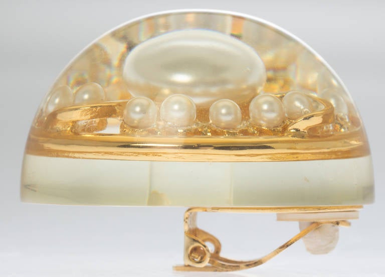 This is an incredible pair of clip on earrings with pearls floating in Lucite half spheres.