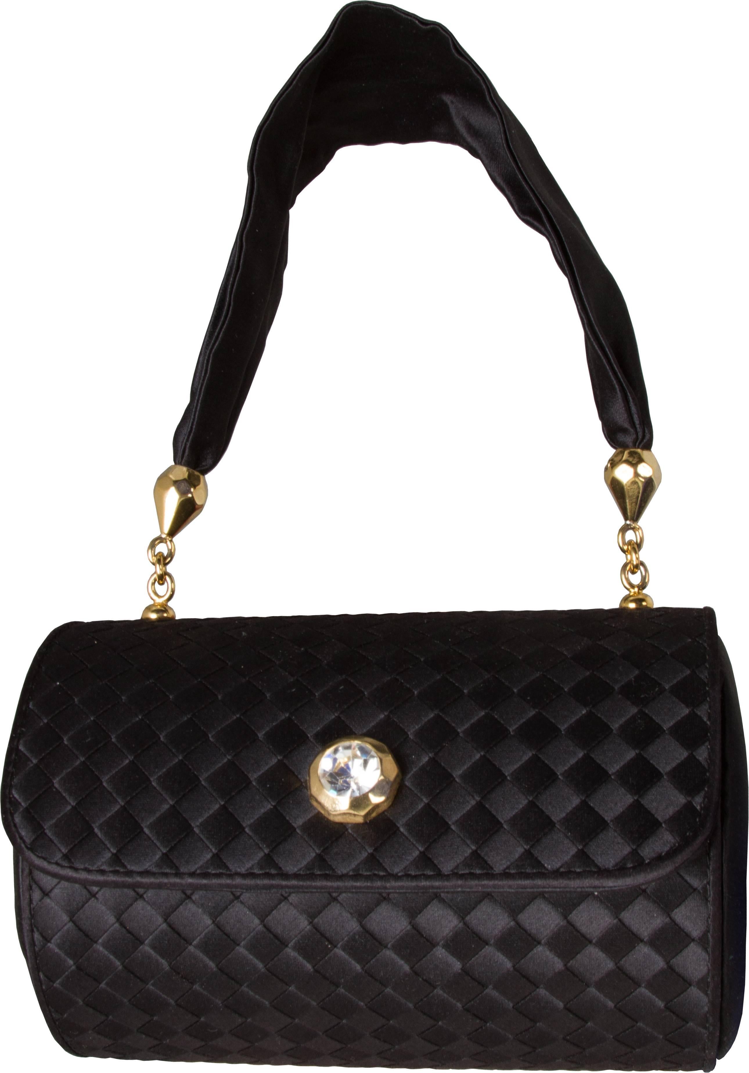 This is an elegant barrel bag accented with gold gilt hardware and a rhinestone closure. 