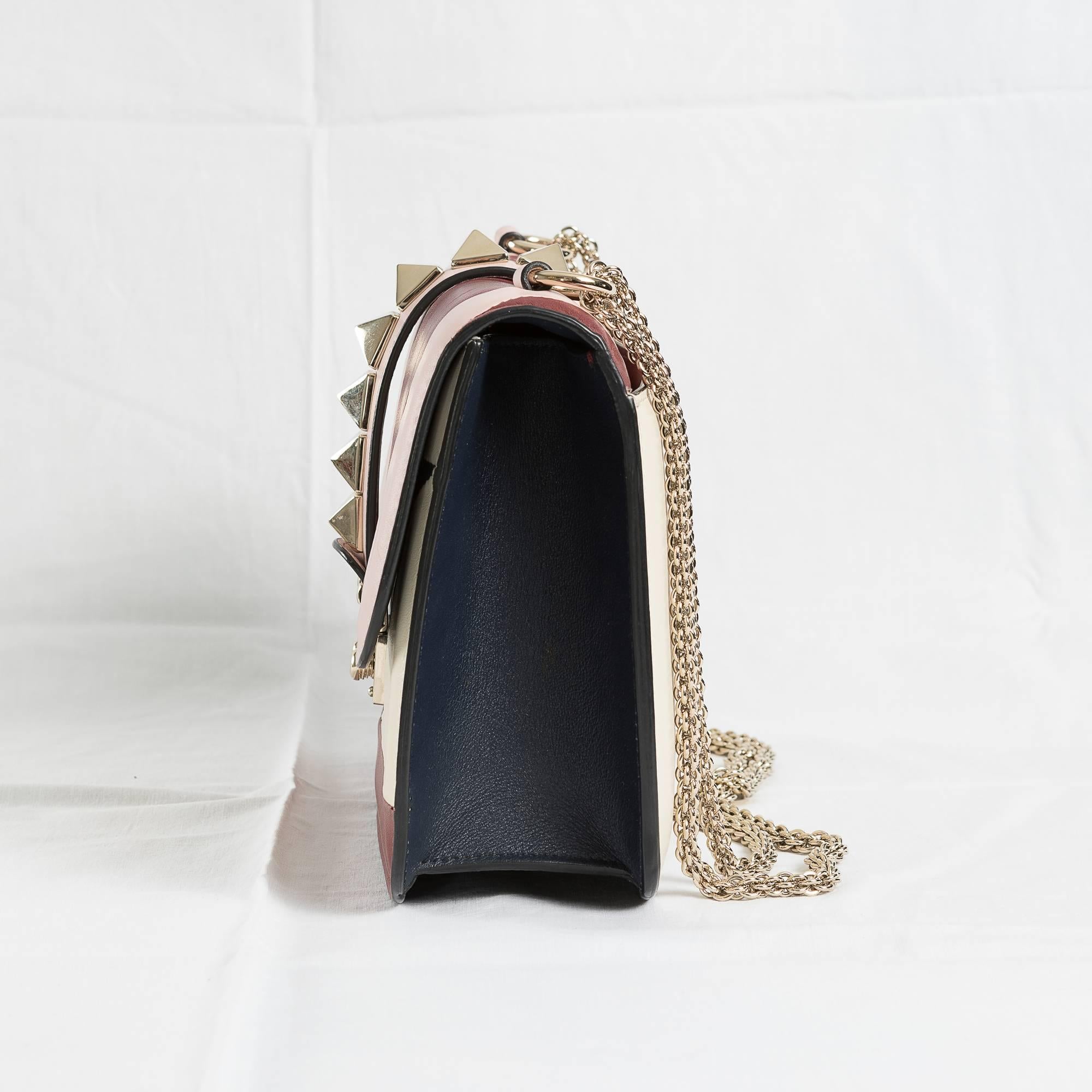 Valentino Garavani's Rockstud Shoulder Bag from the recent past collection of Spring Summer 2016. 
Materials: Leather coloured in blue, ivory, pink and burgundy; golden metal chain and strap.
New, worn only once. 
Rear pocket .
The bag comes with