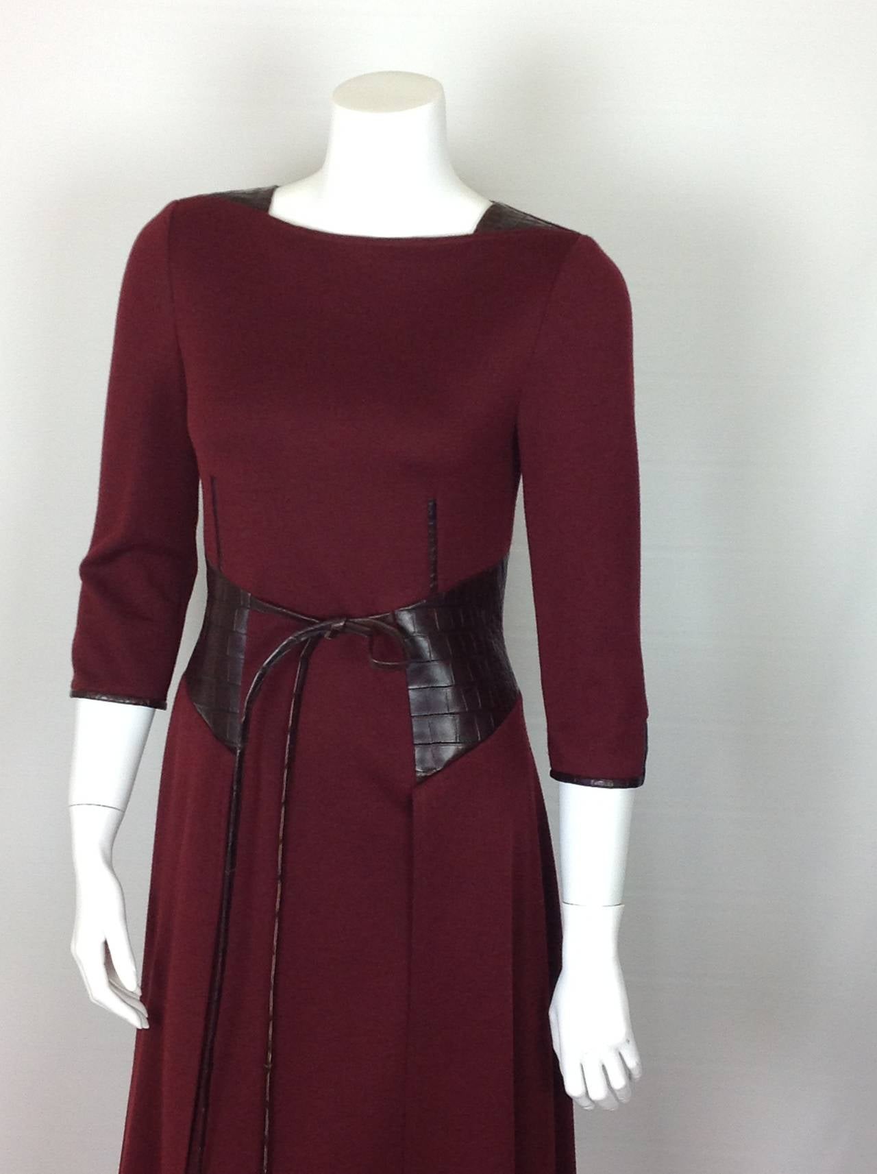 From the Fall 2014 collection, a Ralph Rucci serious business dress.  
Beautiful burgundy knit wool dress with 3/4 sleeves. Skirt overlay. 
Soft leather, printed to look like alligator, corset effect at waist, trims the sleeves, gussets at the