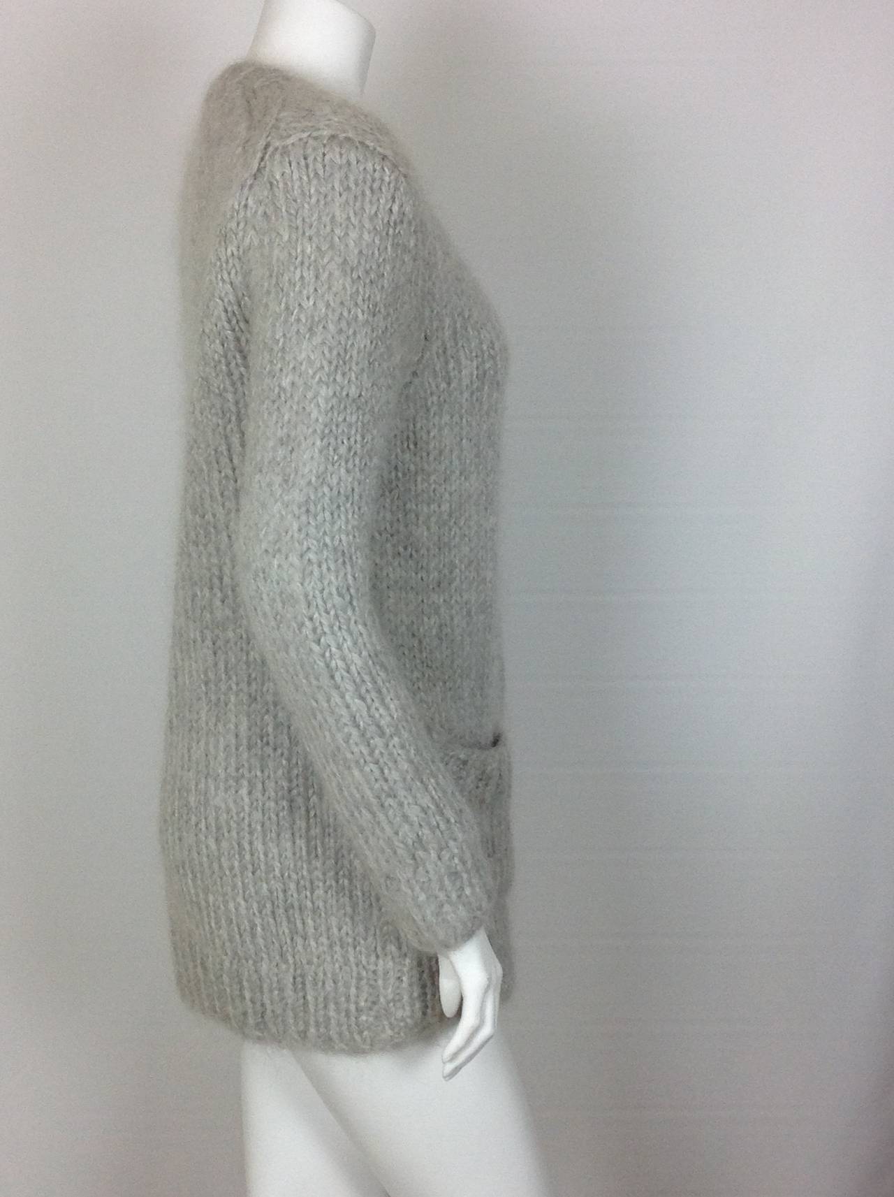 From Fall 2014, pearl gray, chunky knit Michael Kors cardigan.  Sold out!
Hand knitted of mohair, wool and cashmere - Italian yarns.
4 mother of pearl buttons.
2 patch pockets on the front.  
Sold out at $1495.
Shoulder to shoulder 17 1/2