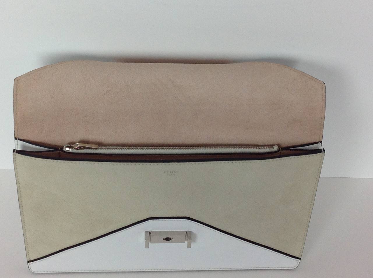Celine Diamond Clutch bag sand suede and white leather.
Lined in natural suede with 3 compartments.  One compartment has a zipper.
Chrome Celine engraved squeeze buckle closure.
Dustbag included. Paperwork still in the bag.
Original retail
