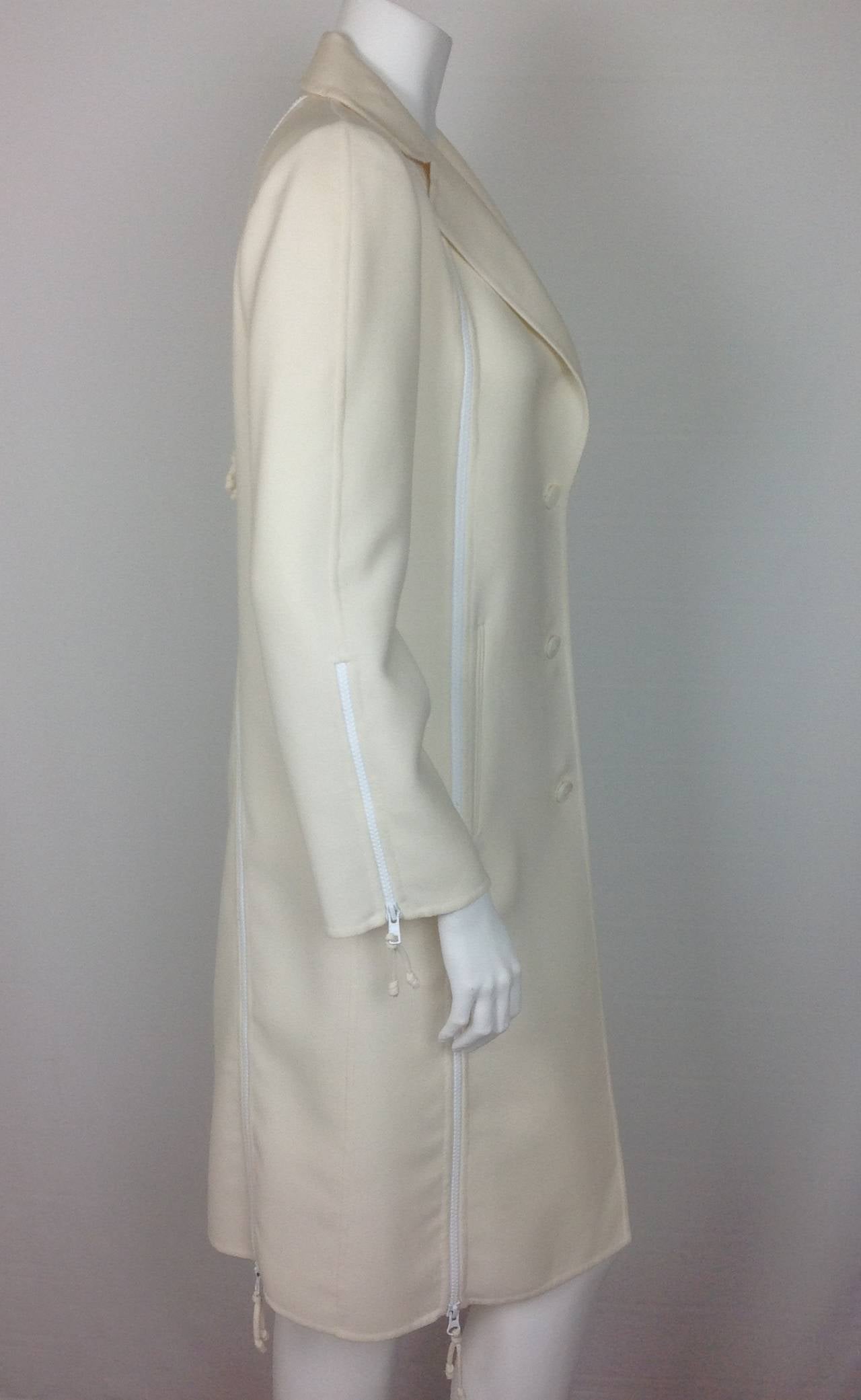 Cream lightweight wool 6 zipper coat by Chado Ralph Rucci.  
All the zippers work.  The full length zippers on the front and back of the coat, work in both directions. The zippers are white nylon, and smooth.
Single breasted 3 button closure.