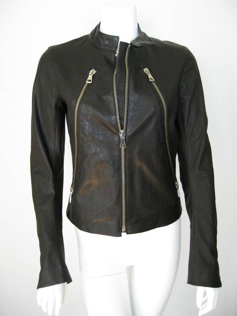 Black leather zippered biker jacket from Maison Martin Margiela. 
Banded snap collar, front zip fastening, front zip pockets, long sleeves and zippered cuffs.
Diagonal long zippers open to working kangaroo pockets.
All zippers work