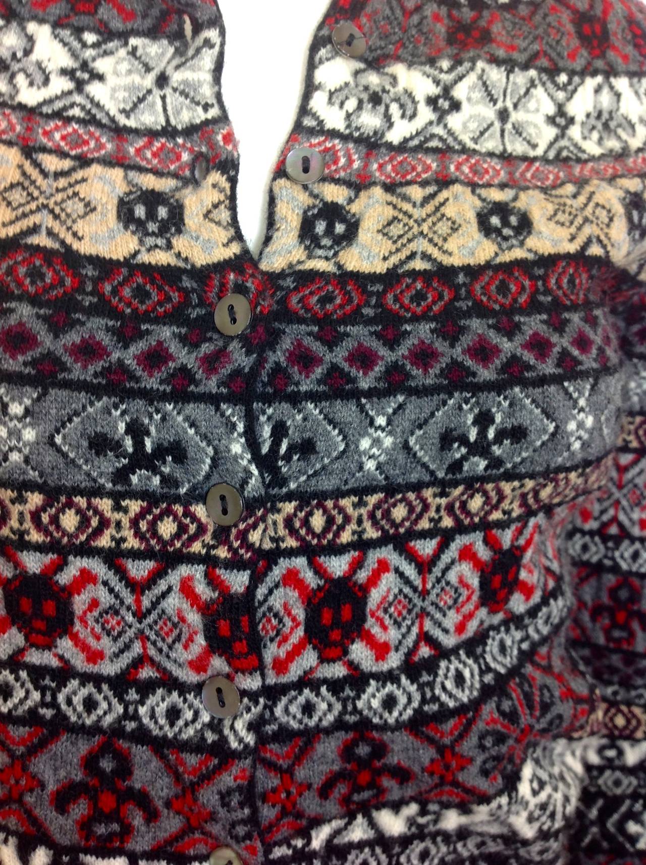 100% wool fairisle cardigan by Alexander McQueen.  McQueen's favorite patterns - skulls,and fleur de lis are woven into this stunning  sweater.
Button front - 10 mother of pearl buttons.  Size S.
Made in Italy of the softest wool. 
The inside of