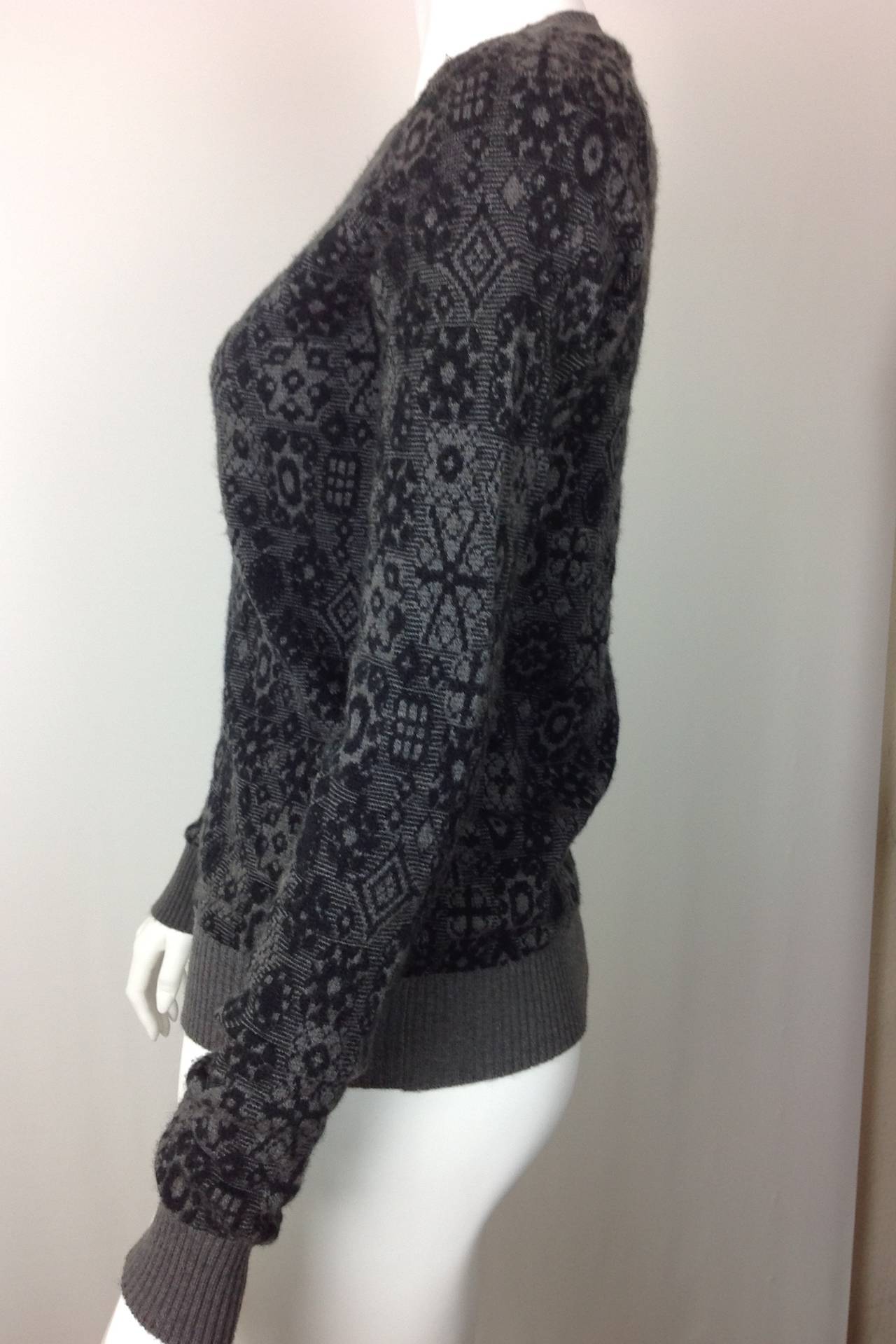 Chanel snowflake sweater in black and charcoal cashmere.  Crewneck pullover. 
Loose crewneck, cuffs and waist is ribbed cashmere in charcoal.
Classic great looks, wear it next to your body, or with a turtleneck or blouse underneath for additional