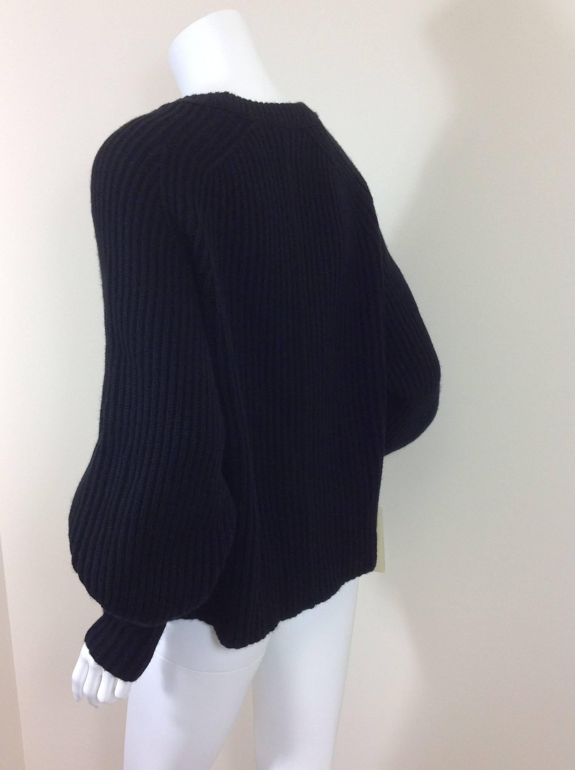 Chunky ribbed black sweater by The Row. Round neck, raglan sleeve knit in. 
50% cashmere, 50% silk, Made in the USA of imported yarn.
Currently in the collection for $2072.
Beautiful construction, and lovely fabric.  Boxy fit.  36