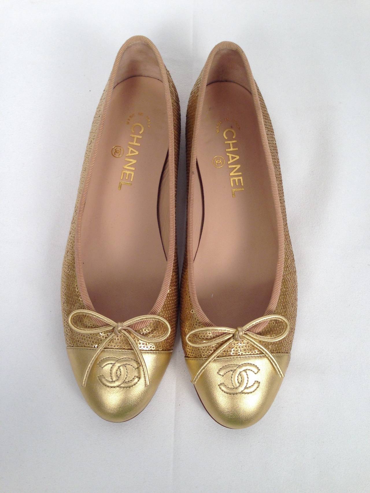 Shine on in these classic Chanel Leather and Gold Sequin Ballerina Flats With Metallic Gold Cap Toe.  Features include CC logo stitched cap, metallic leather bow at the vamps, grosgrain ribbon trim, wooden heels and leather lined insoles.  Excellent
