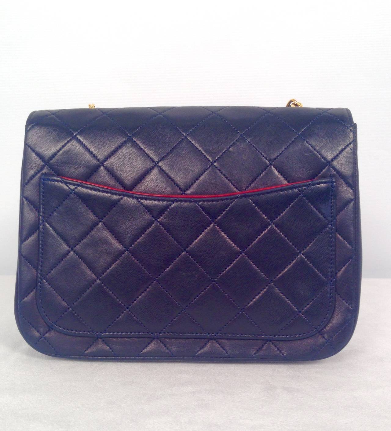 Vintage Chanel Navy Lambskin Bag is an excellent example of Chanel Chic!  Fit for a lady, supple navy lambskin is quilted in diamond AND vertical patterns.   Features include gold tone hardware, external back pocket, signature double 