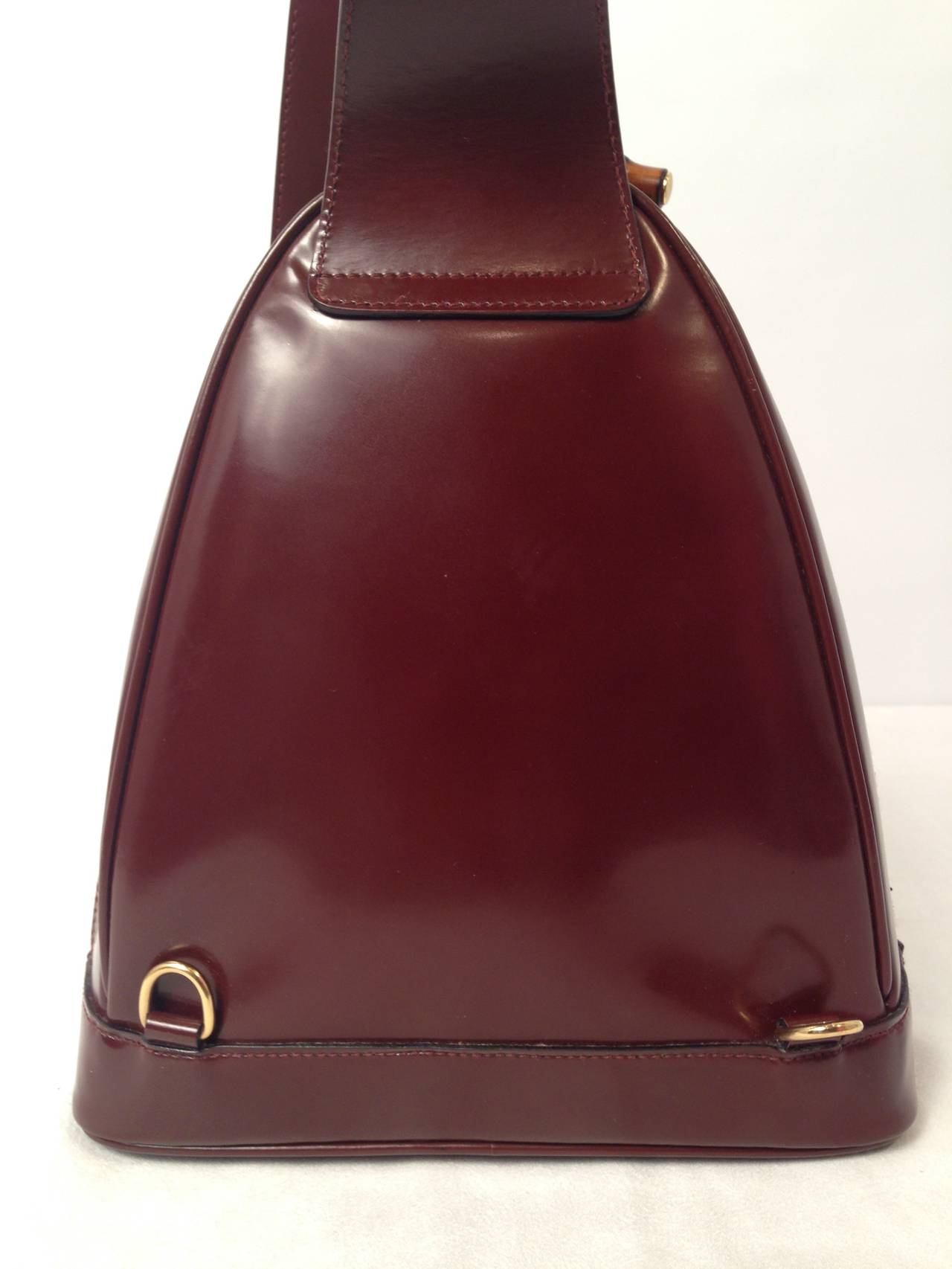 Relive the glory days of Tom Ford at Gucci with this stylish brown polished leather backpack!  It offers a main compartment and small front pocket embellished with a discreet Gucci signature stamp on the center.  The  main compartment features a top