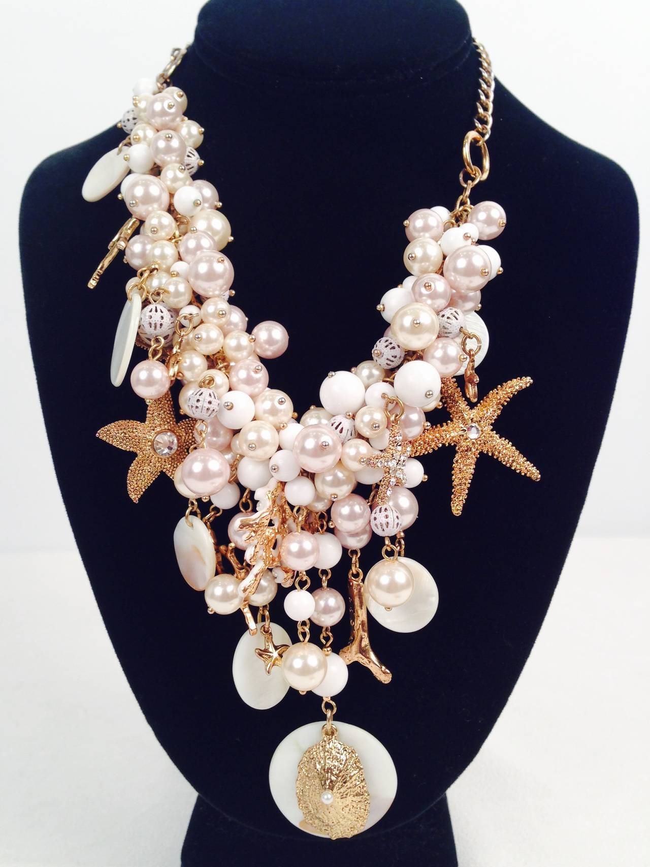 What a fabulous Summer Statement piece!  Gold tone metal, open work beads, costume pearls, white beads and sea-themed charms will have you dancing down the beach in style!  Lobster clasp; length is 21