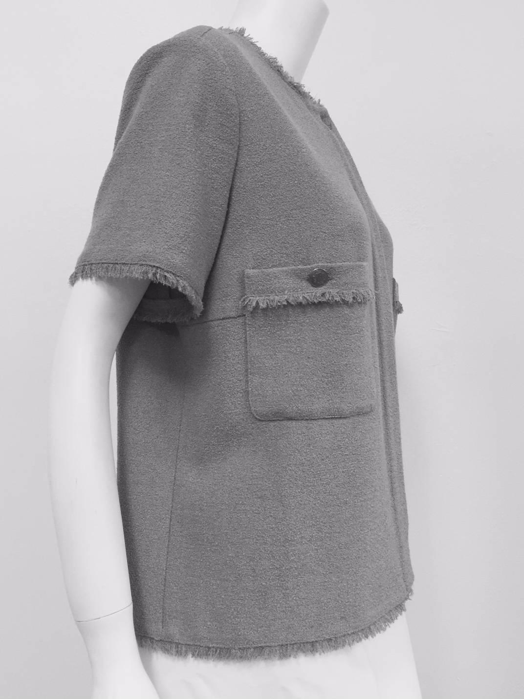 Chanel 2008 Steel Grey Wool Short Sleeve Blouse is a perfect cruising attire.  Though designed for tropical weather, fabric is substantial enough for unexpected breezes and cooler evenings.  Round neckline, placket front and two patch pockets with