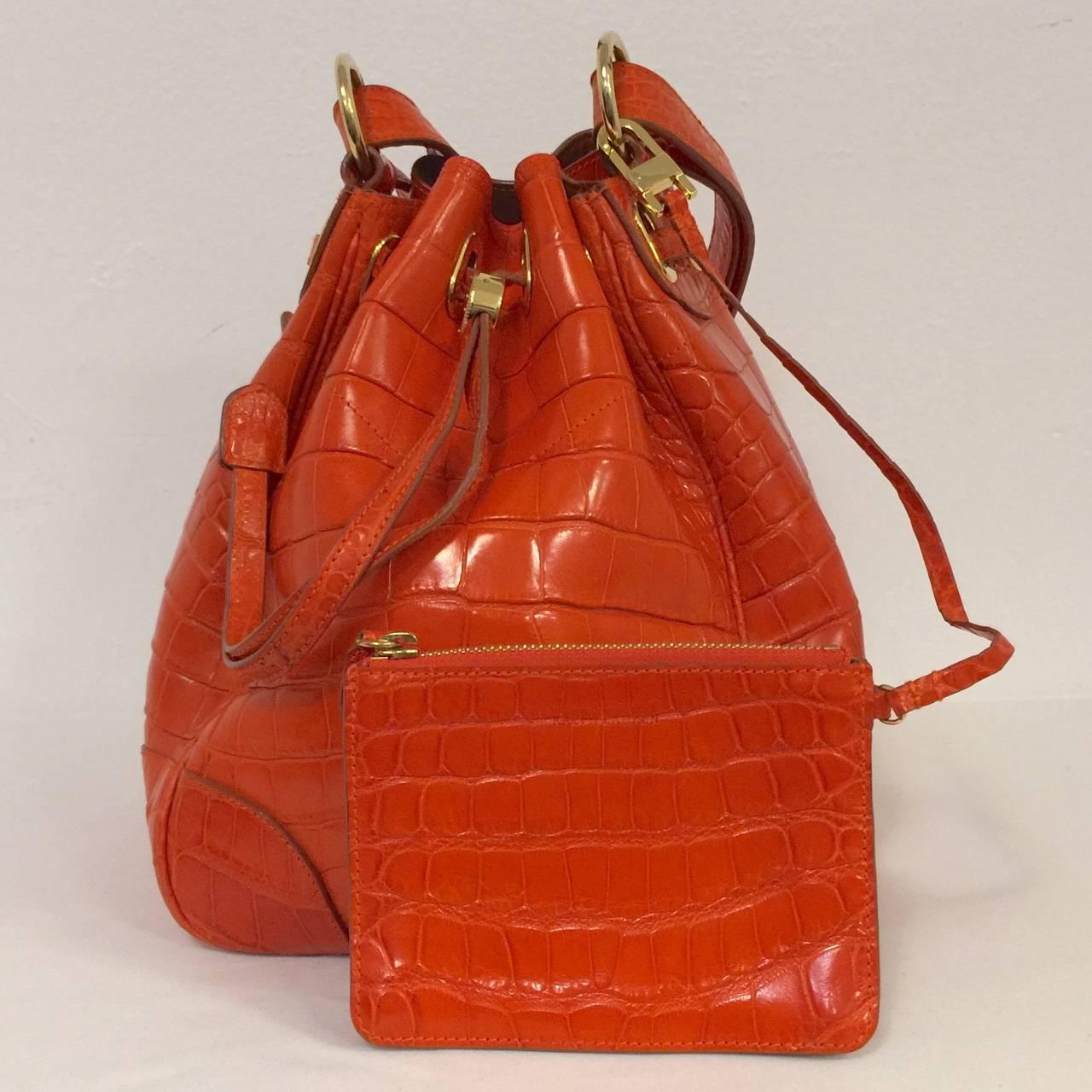 Orange Alligator Bucket Bag illustrates why Ralph Lauren has become America's preeminent designer of luxury goods!  Crafted from only the finest alligator skins, this bag's wow factor is elevated by a most luscious shade of deep orange.  Features