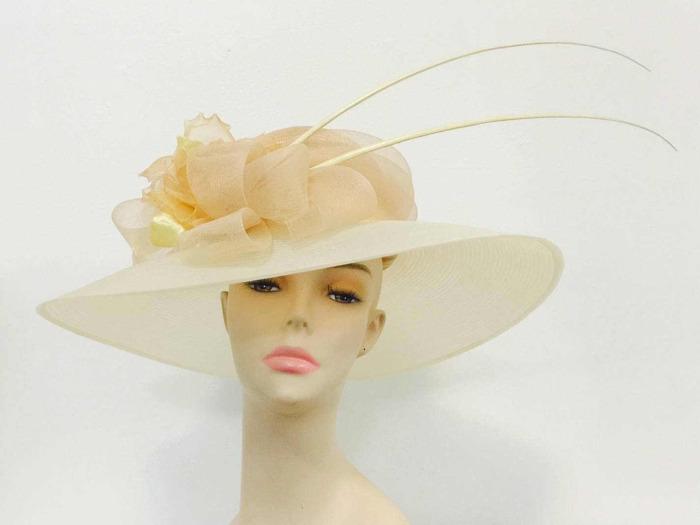 Peter Bettley Wide Brimmed Hat is sure to please all admirers!  Features most feminine shades of vanilla and peach!  Wide vanilla brim is perfectly complemented by peach straw crown, flower and exotic feather detail.  Bow?  But of course!   Is it