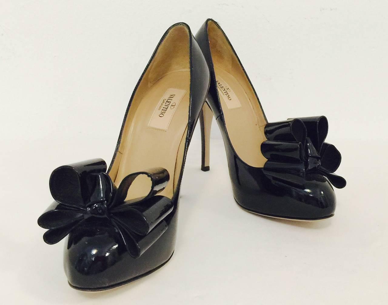 Black Patent Leather High Heel Pumps are typical Valentino... Feminine, flirty, and fit for any siren!  Features ultra-luxurious patent leather, covered platform and three-tiered bow decoration.  Leather soles, insoles and lining.  Made in Italy.