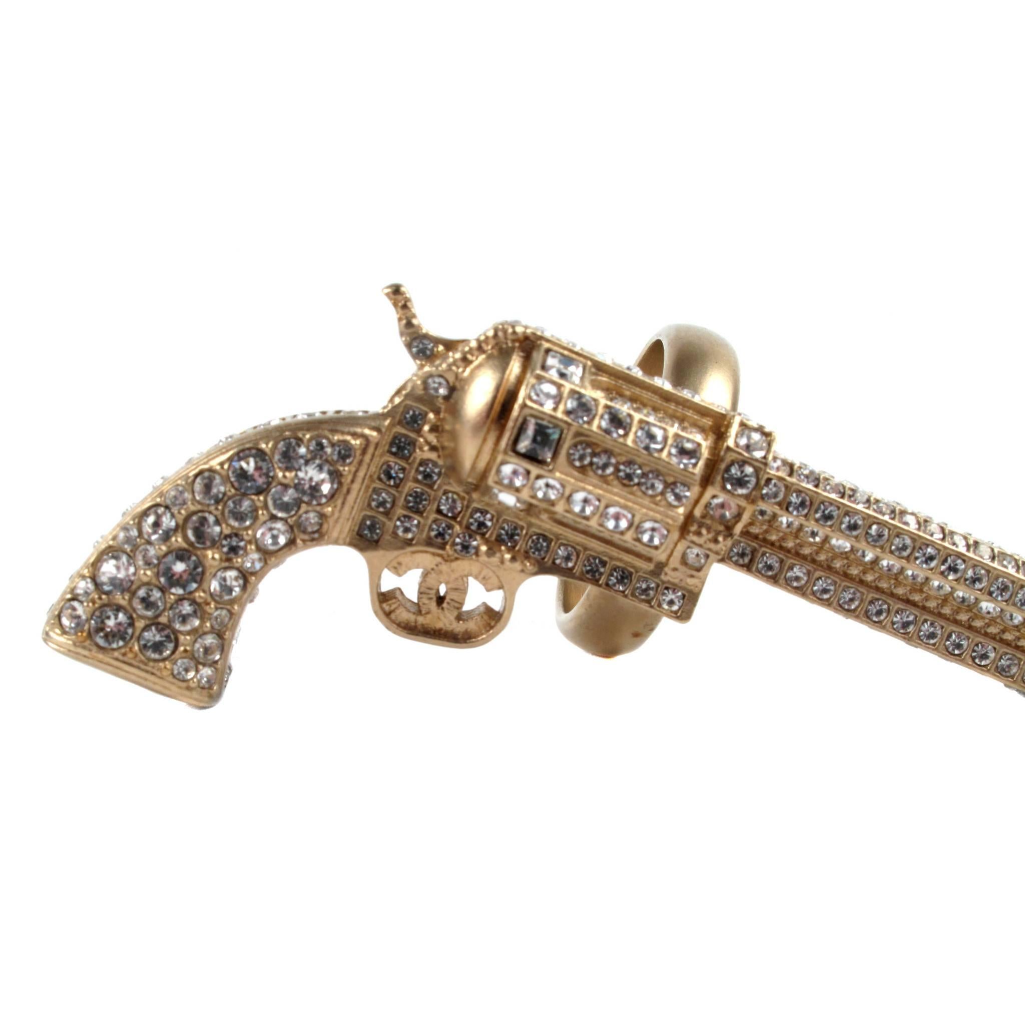 Make an unforgettable statement with this New Chanel Gold Tone Pistol Ring.  Edgy?  Highly collectible?  Mais oui!  Introduced as part of the Fall 2014 Collection, ring features gold tone metal and clear Strass crystals.  Double 