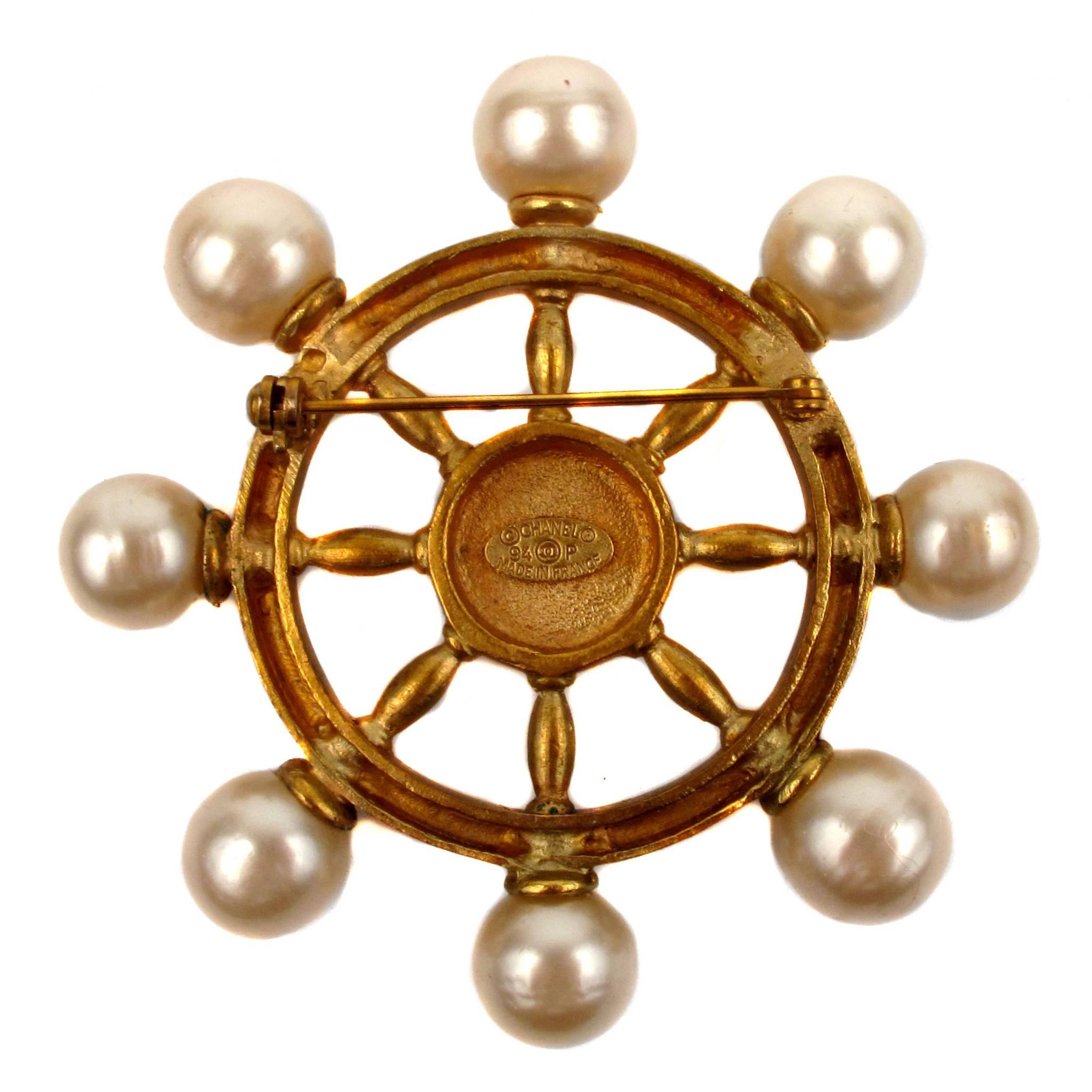 Chanel 1994 Spring Ship Wheel Brooch may be worn a myriad of ways...on a lapel, at the waist, or even as a final flourish to a tied scarf!  Pin features gold tone hardware, pearls, and the inimitable double 