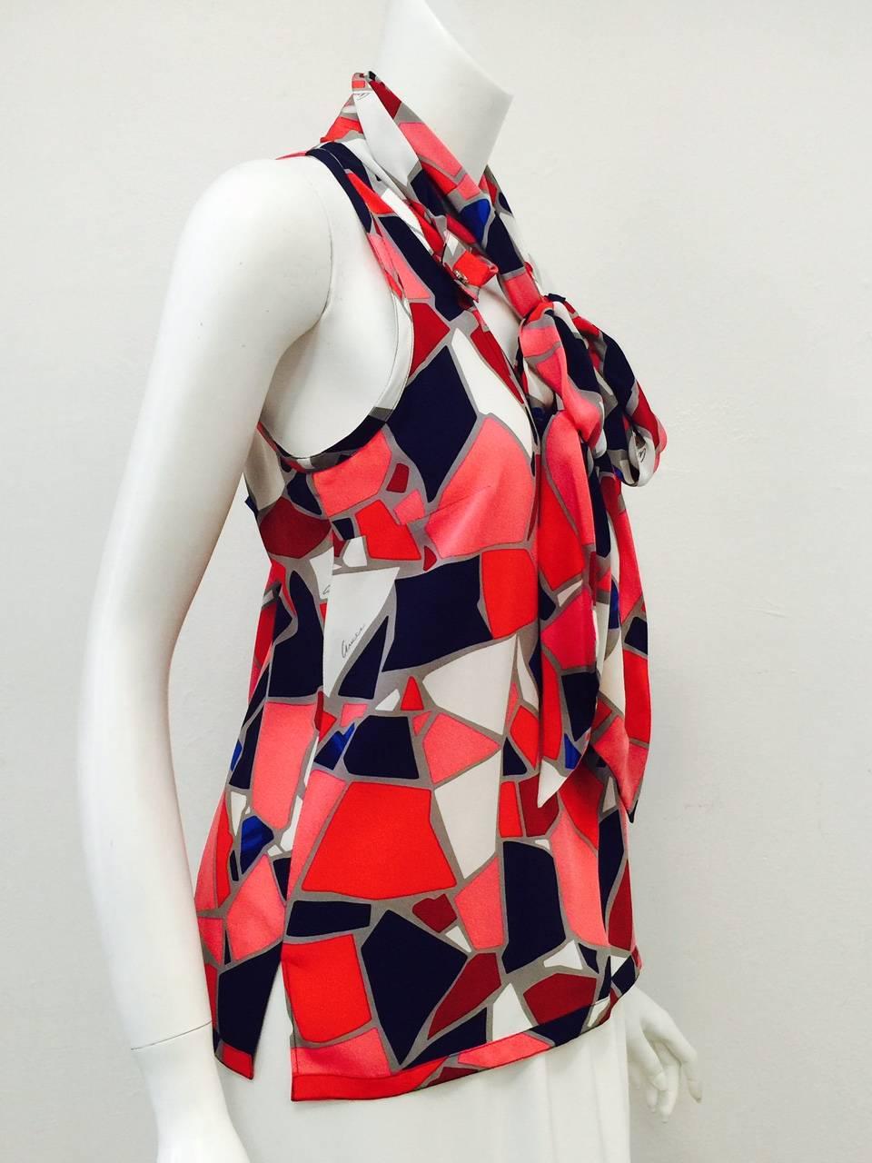 Gucci Silk Sleeveless Blouse is ageless and timeless!  Features bold abstract print in shades of navy, royal blue, red, burgundy, and rouge.  Elongated oval neckline incorporates voluminous, adjustable tie attached at the back of the neck and
