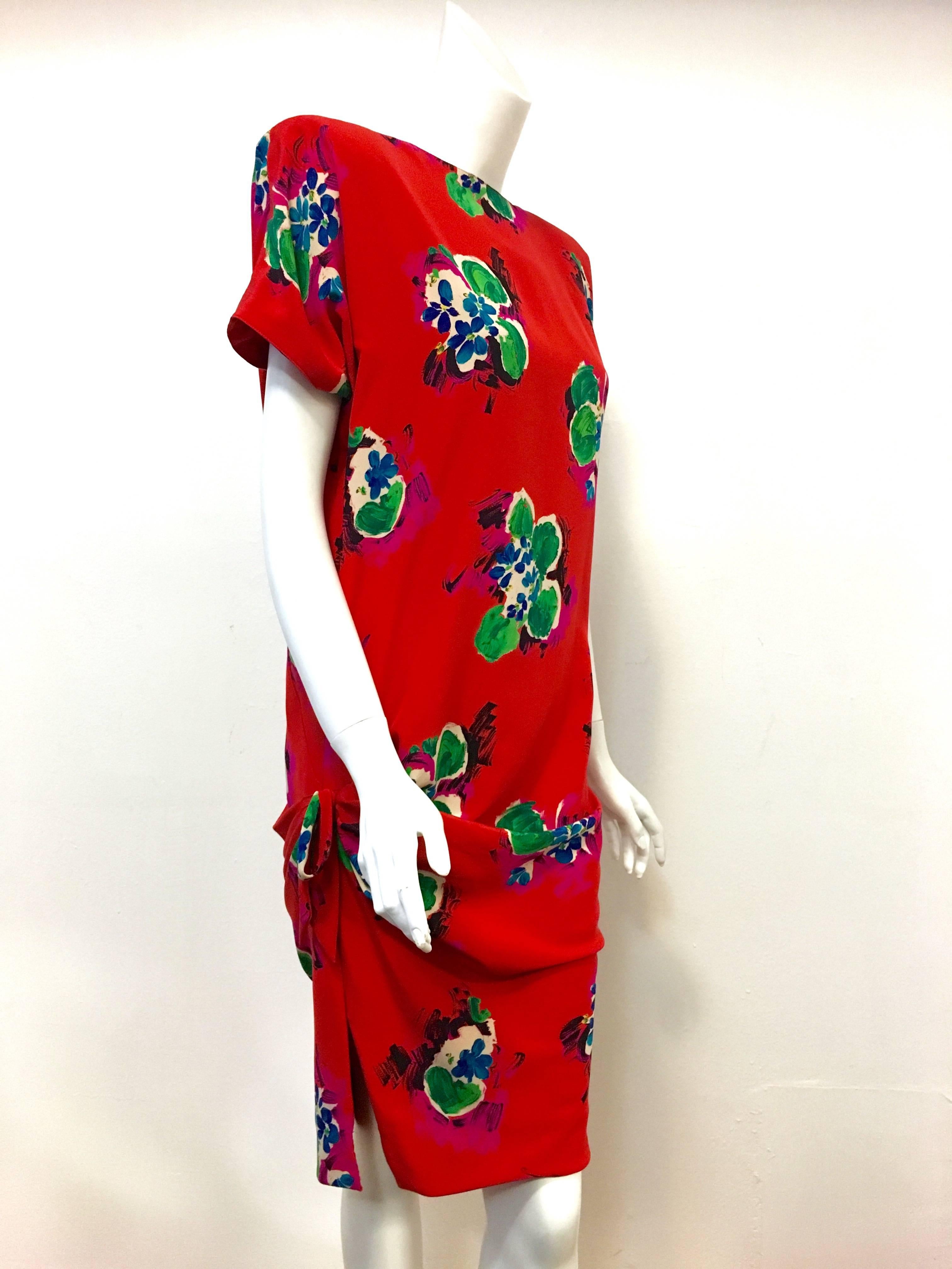 Walk your own red carpet in this stunning Ungaro floral print dress.  Details abound beginning with a round collar that dips to a V in back which fastens with snaps.  One front side is gathered into a permanent tie that points one slit