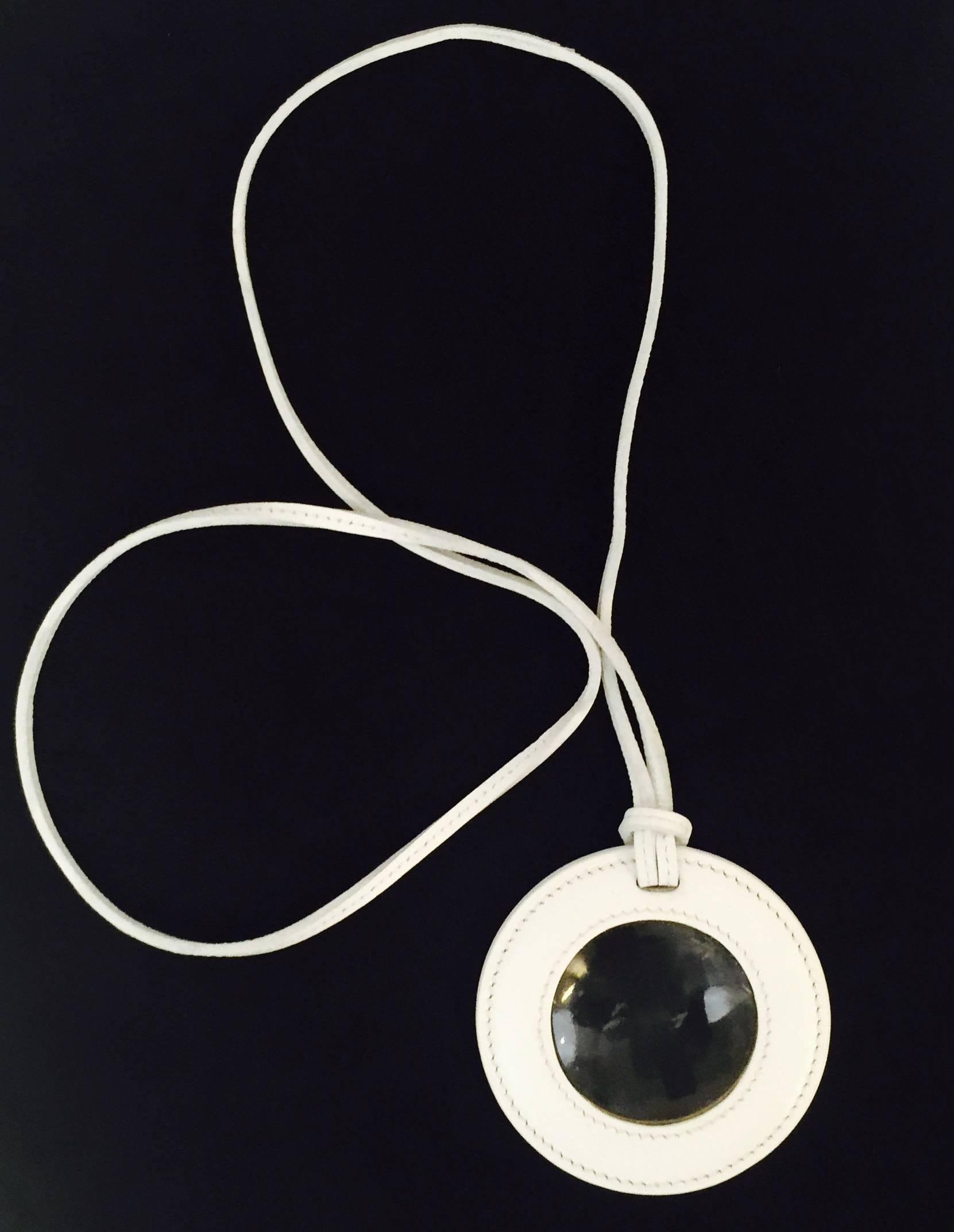 Round Magnifying Loupe is a must for aficionados of all things Hermes!  Features undeniably luxurious white leather frame and necklace.  In above excellent condition...glass is actually still sealed!  Made in France.  Desired everywhere!  Original