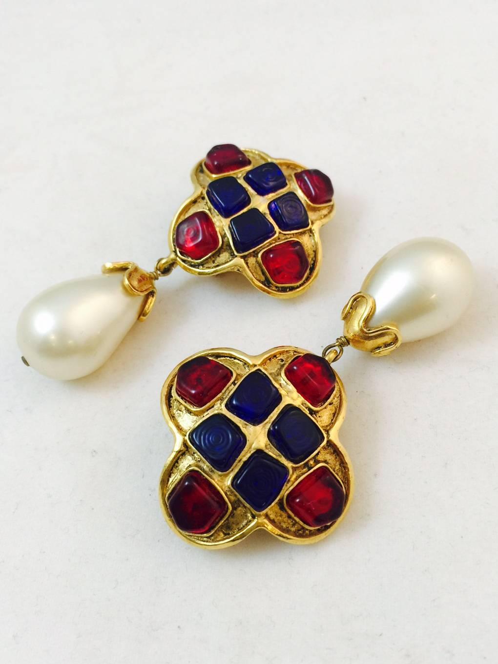 Oh, so very Coco!  Stunning clip on earrings feature a clover shape gold tone top replete with blue and red gripoix stones.  Dangling from the shield are tear drop shape faux pearls measuring an impressive 17.5mm at their widest point.
End caps on