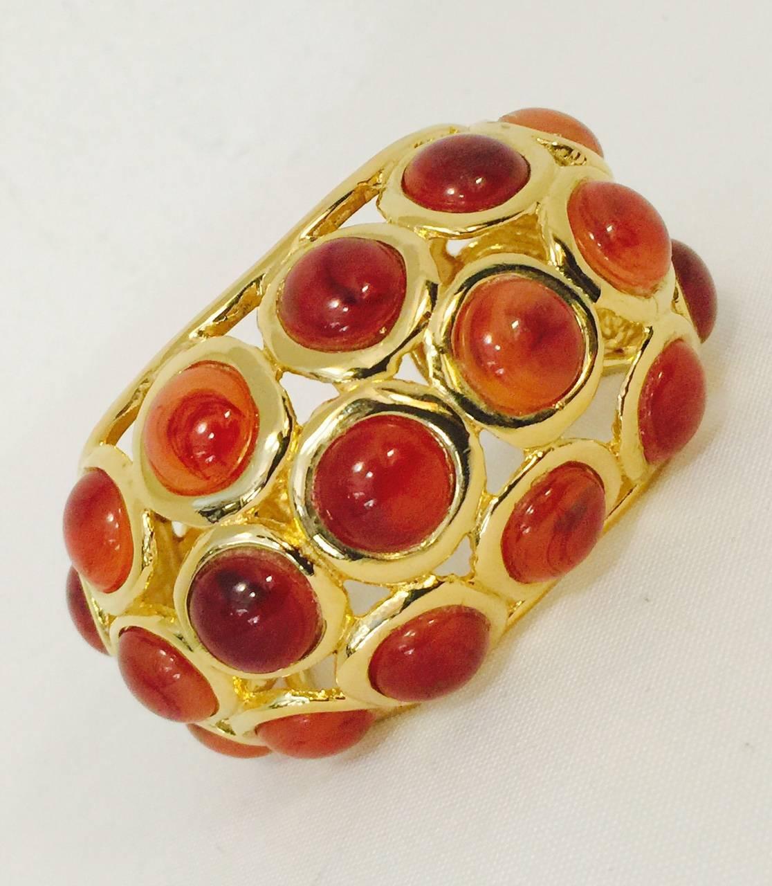 Kenneth Lane creates fabulous items that are both distinct and ever so wearable! This fantastic hinged cuff is a bold, powerful accessory for so many occasions.  Fabricated with cabochon resin resembling carnelian.  Finished in a beautifully