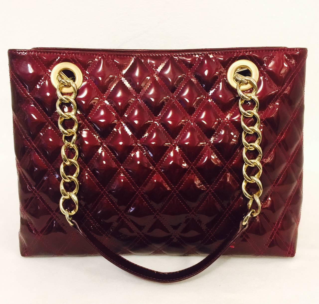 Stuart Weitzman is so much more than shoes!  This Cherry Diamond Quilted Iridescent Patent Leather Tote will quickly become a favored go-to carryall in town and country.  Features gold tone chains with smooth cherry shoulder straps.  Open top with