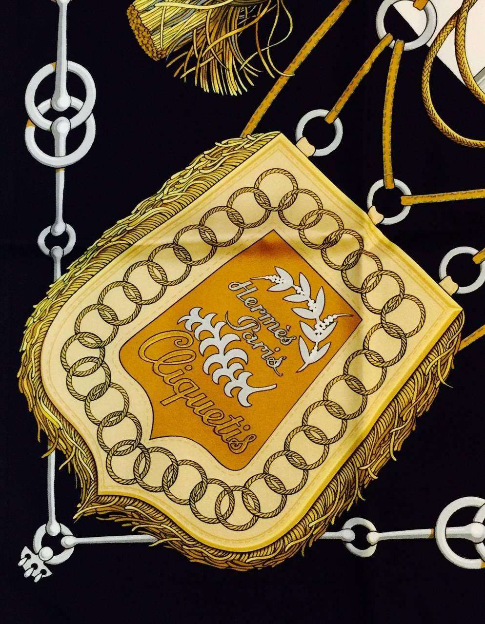 Introduced in 1972, Hermes Red Cliquetis Silk Carre by Julie Abadie has become a highly desired print by collectors around the world. Scarf features varying sword and tassel tops in shades of gold over a black and white colorway. 100% silk twill