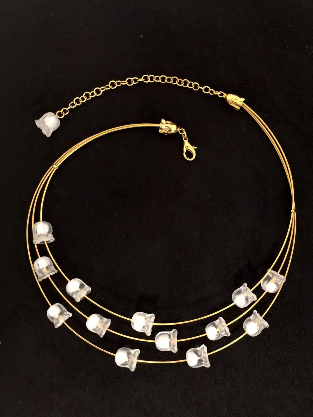 Lalique's frosted crystal is recognizable from afar!  Muguet is French for Lily of the Valley.  Small stationary flowers adorn three gold colored coils.  One crystal flower dangles at the end of the adjustable lobster claw chain extender.  Lily of